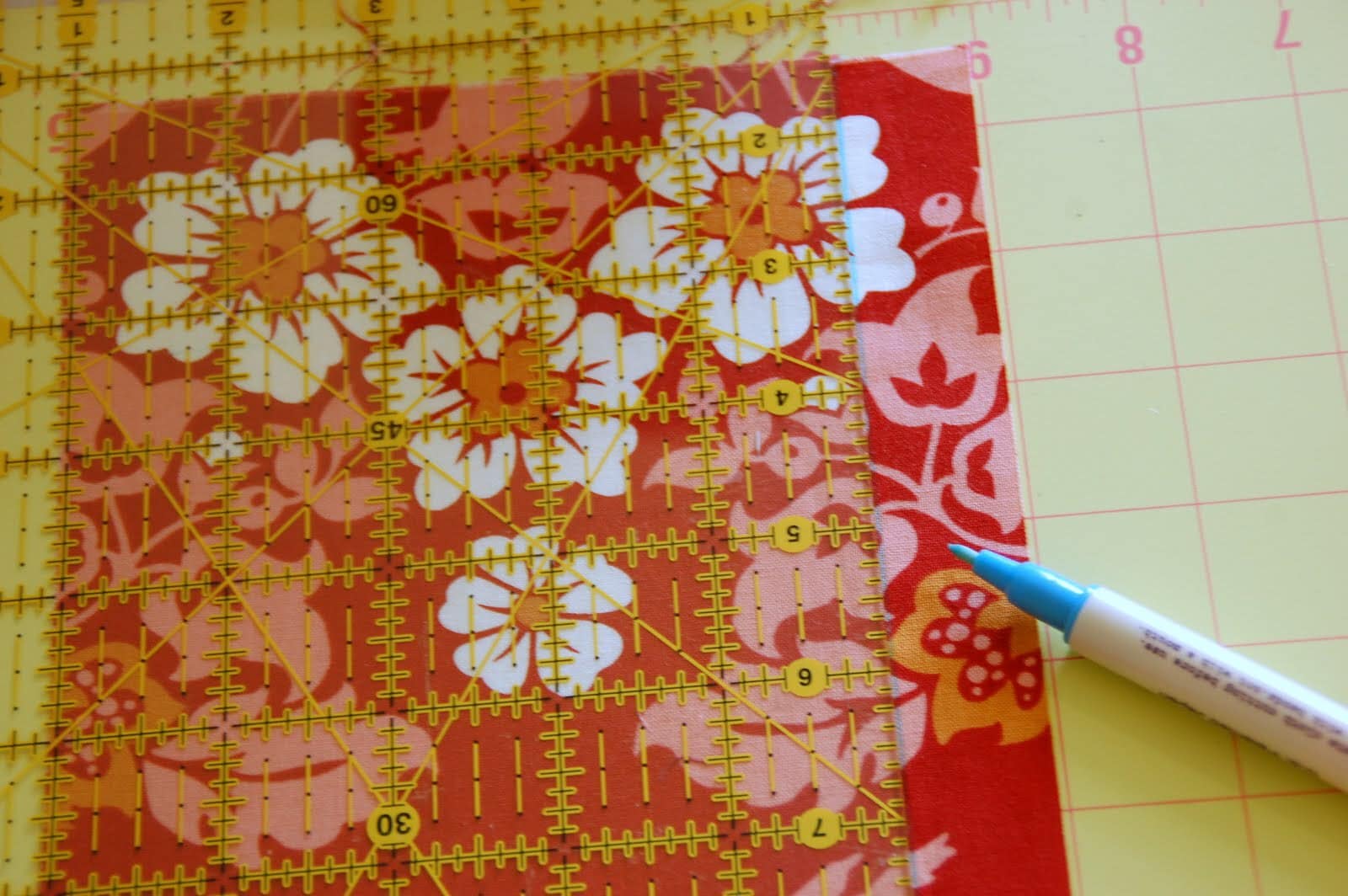red, blue and coral fabric during construction process with sewing notions