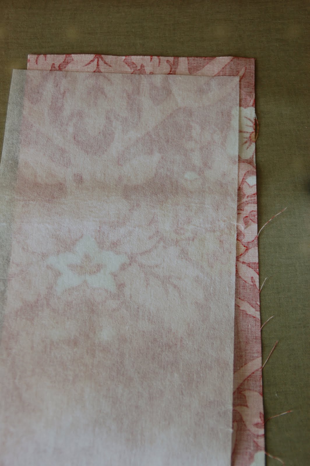 red, blue and coral fabric during construction process with sewing notions