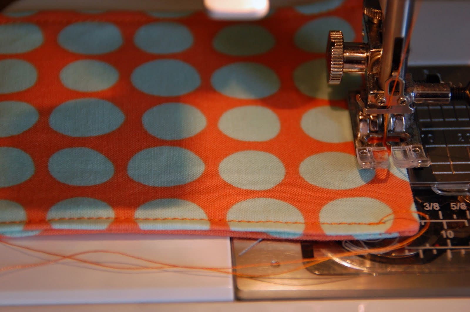 red, blue and coral fabric during construction process with sewing notions
