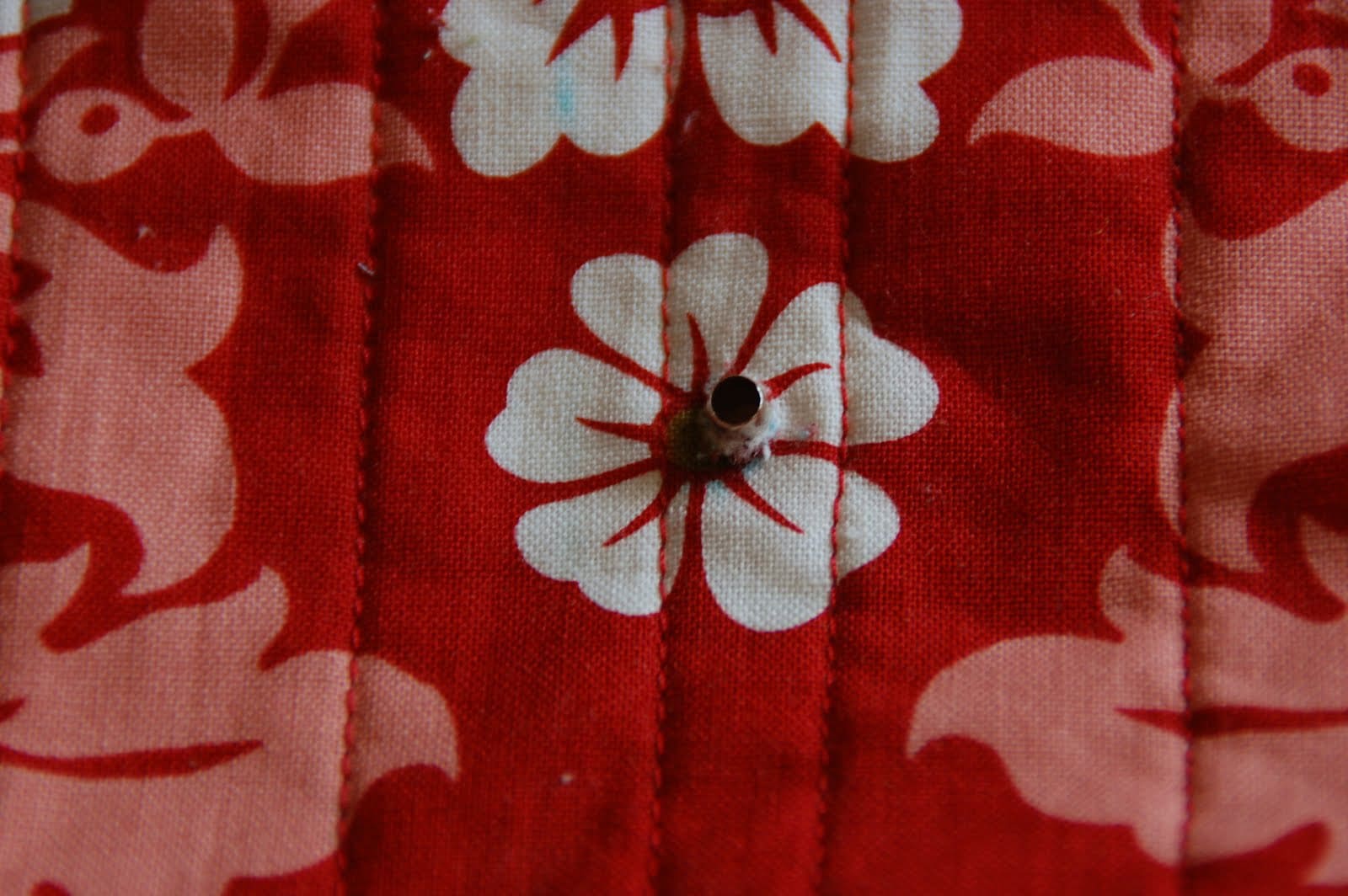 red, blue and coral fabric during construction process with sewing notions