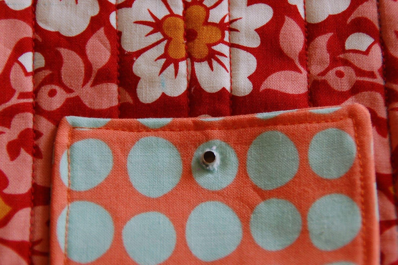 red, blue and coral fabric during construction process with sewing notions