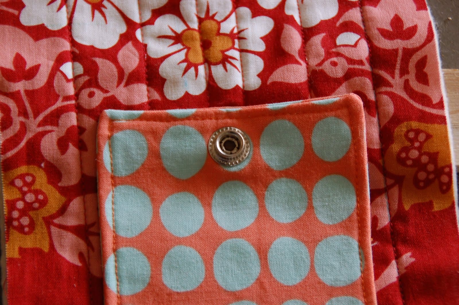 red, blue and coral fabric during construction process with sewing notions
