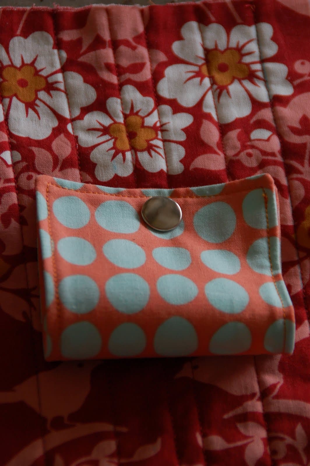red, blue and coral fabric during construction process with sewing notions