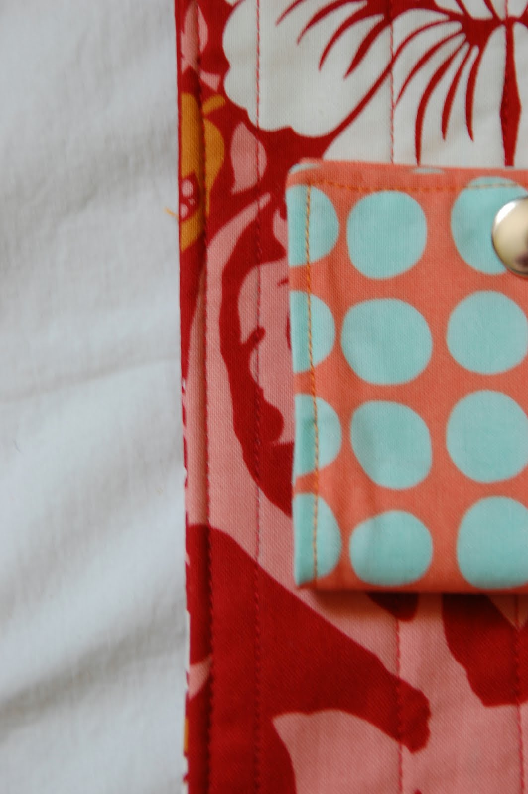 red, blue and coral fabric during construction process with sewing notions