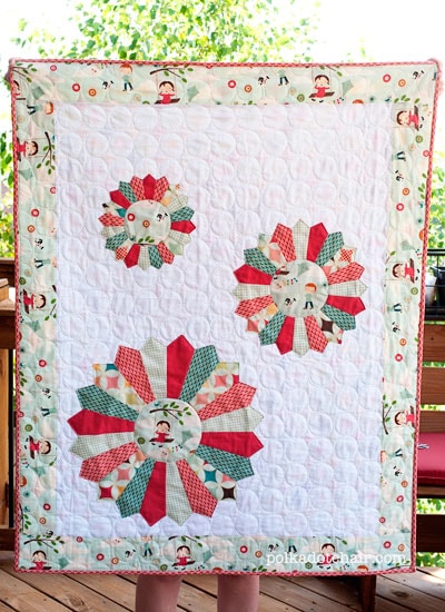 Colorful Dresden Burst baby quilt with on wall