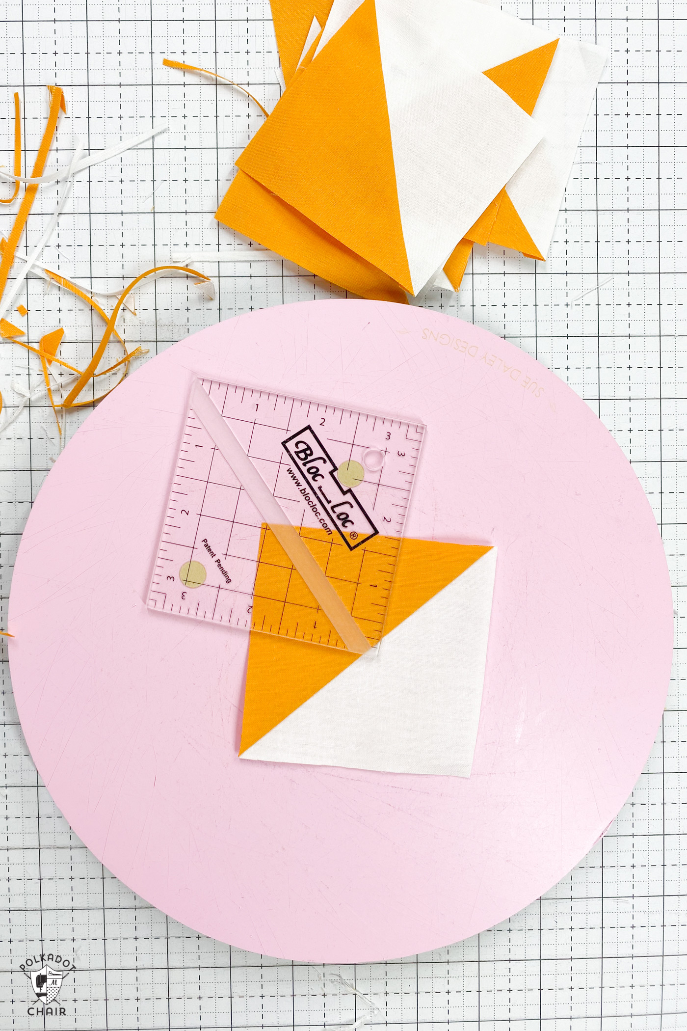 yellow and white quilt block on pink cutting mat