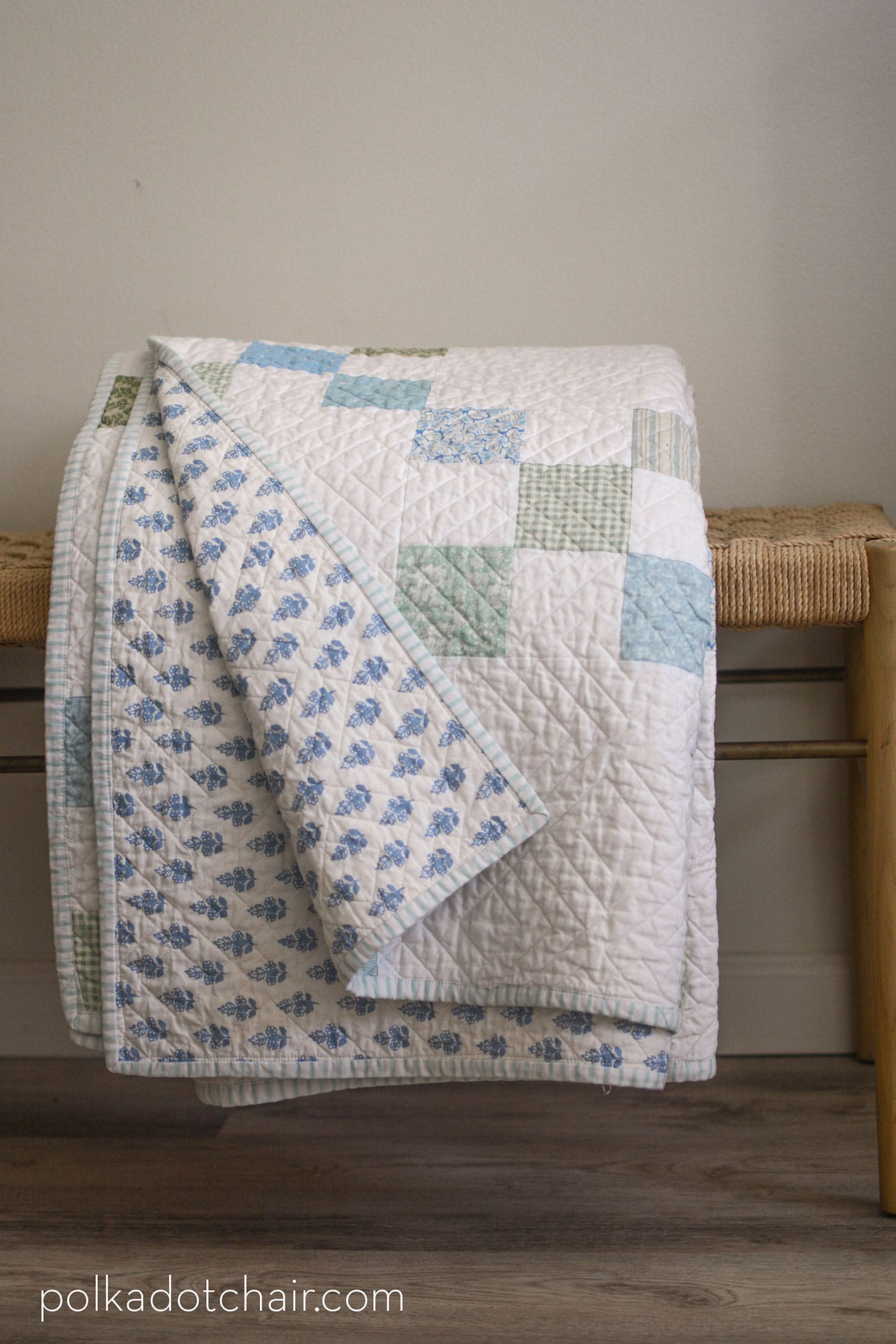 blue and white quilt folded on bench