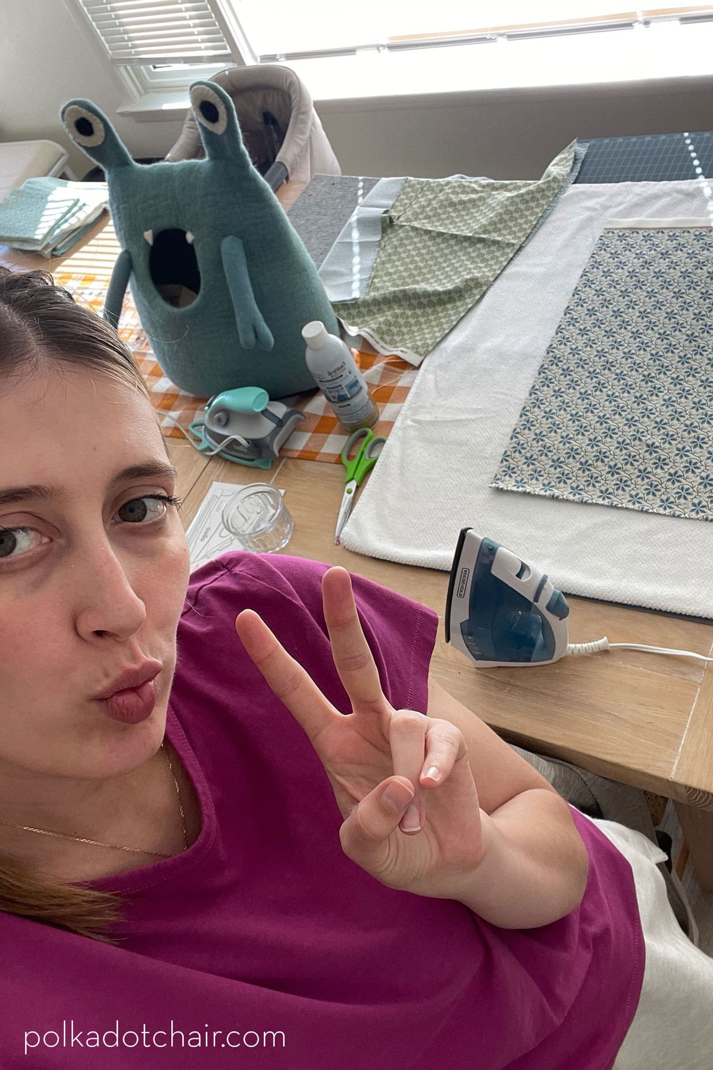 woman taking selfie with quilt supplies in background