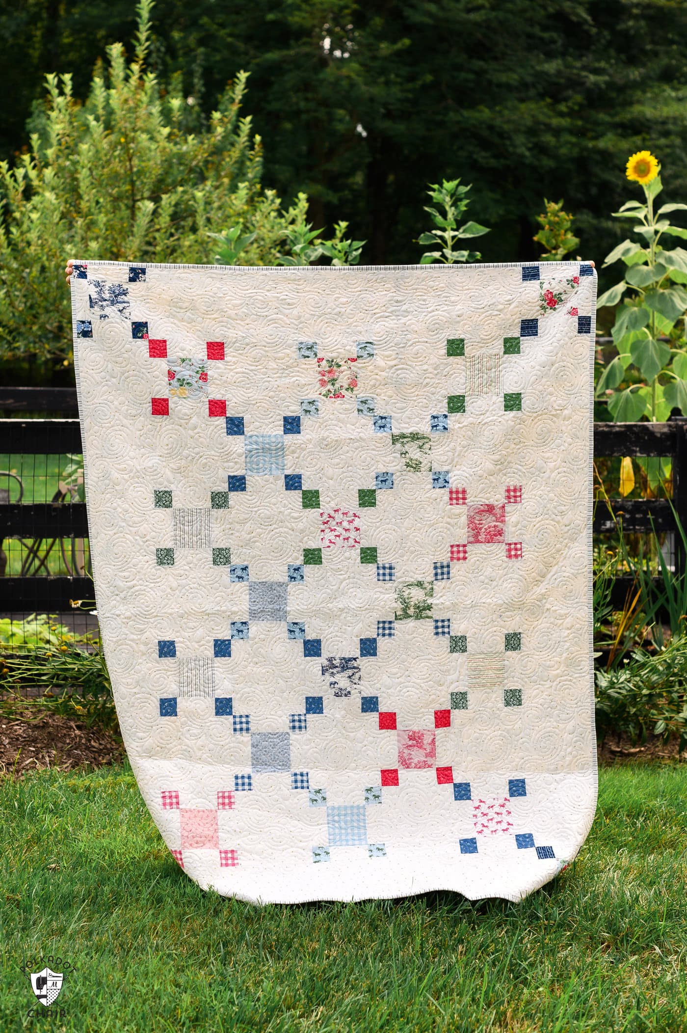 colorful chain quilt outdoors with flowers and greenery