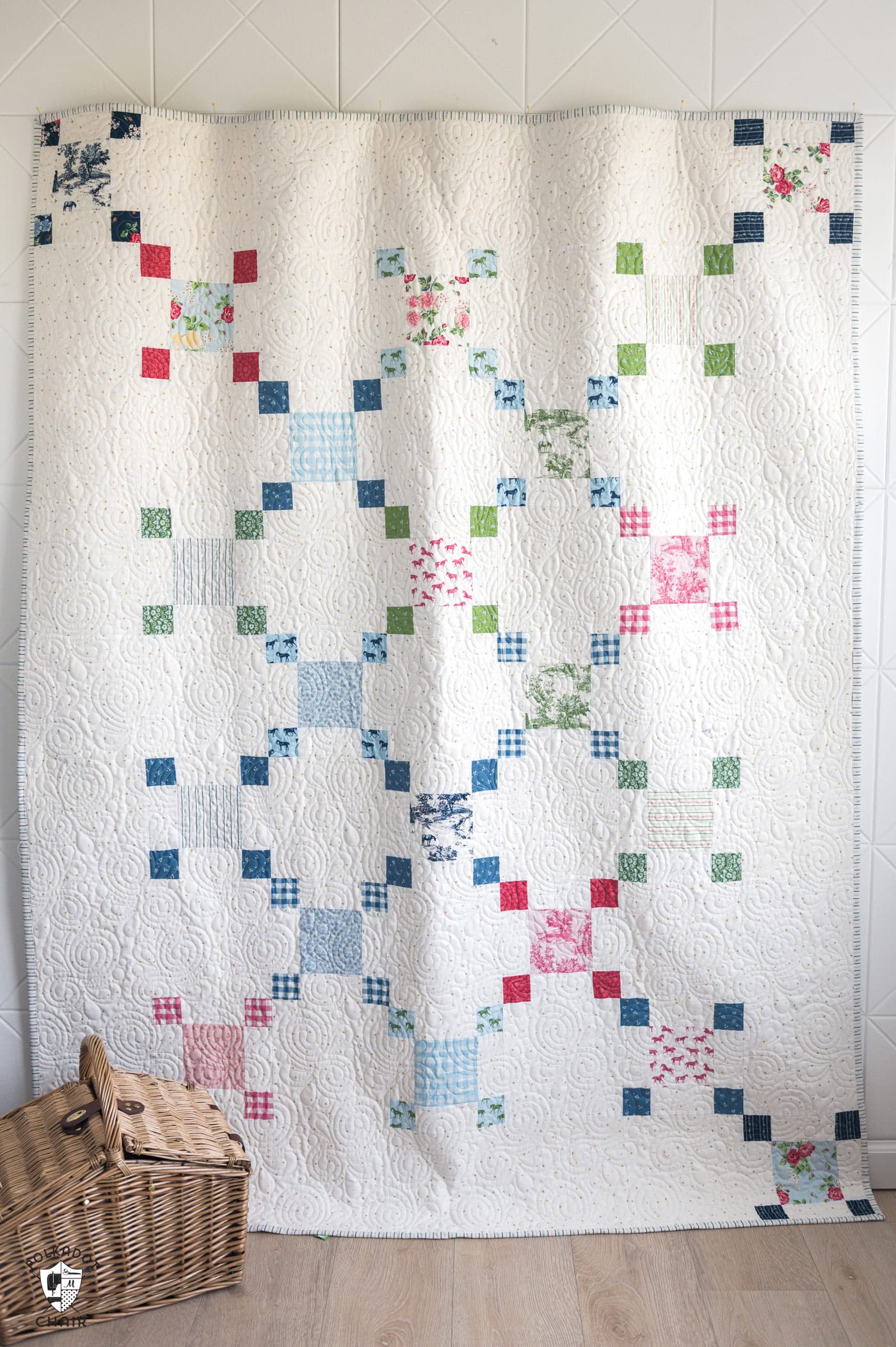 white Irish chain inspired quilt hanging on wall