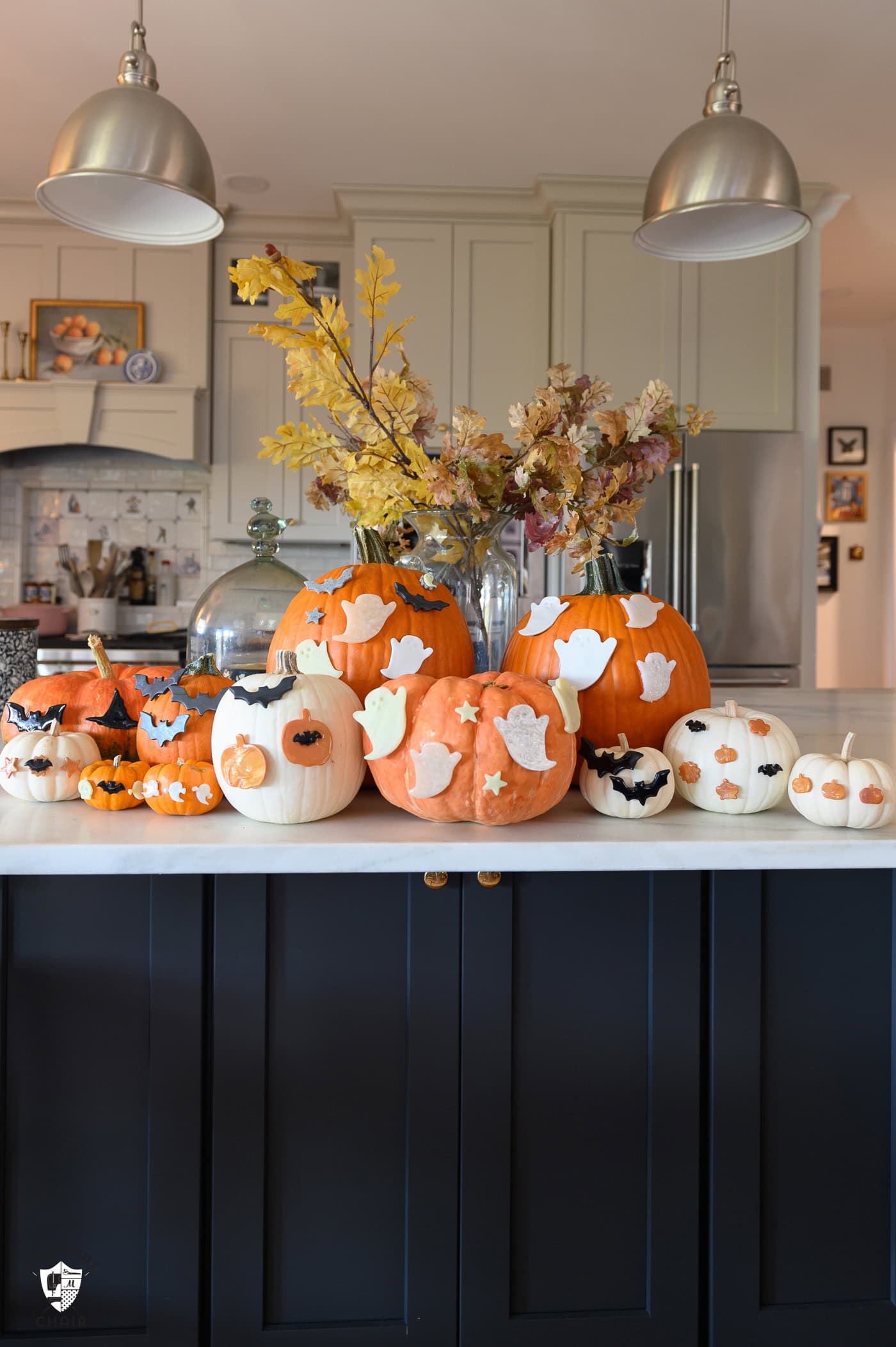 multiple decorated pumpkins on kitchen counter