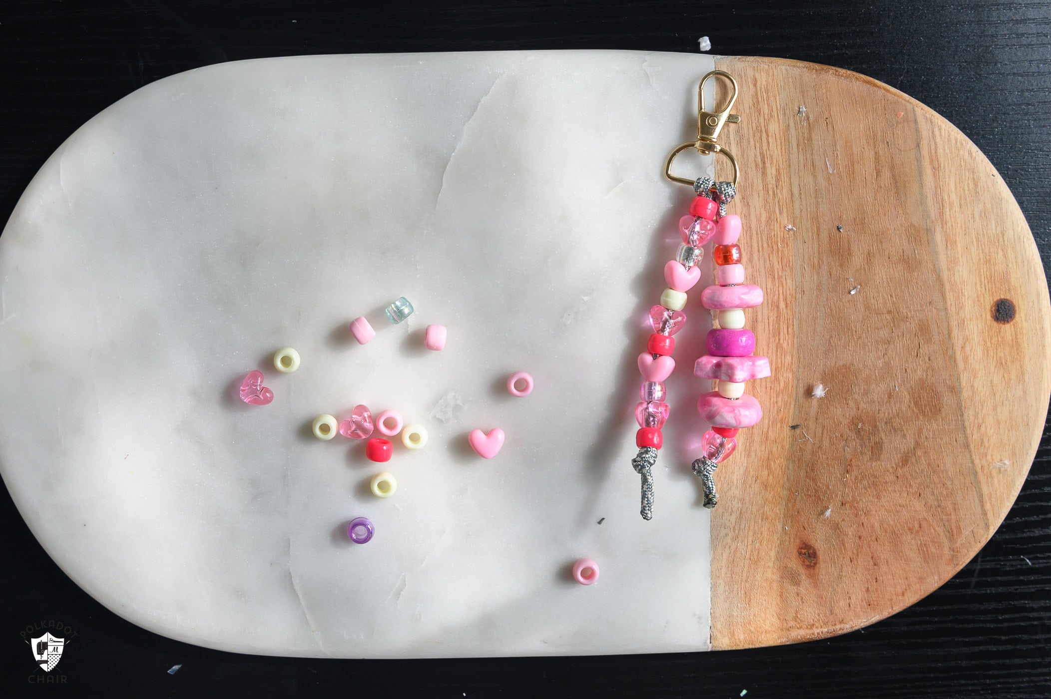 keychain with pink beads next to spread out leftover pink beads.