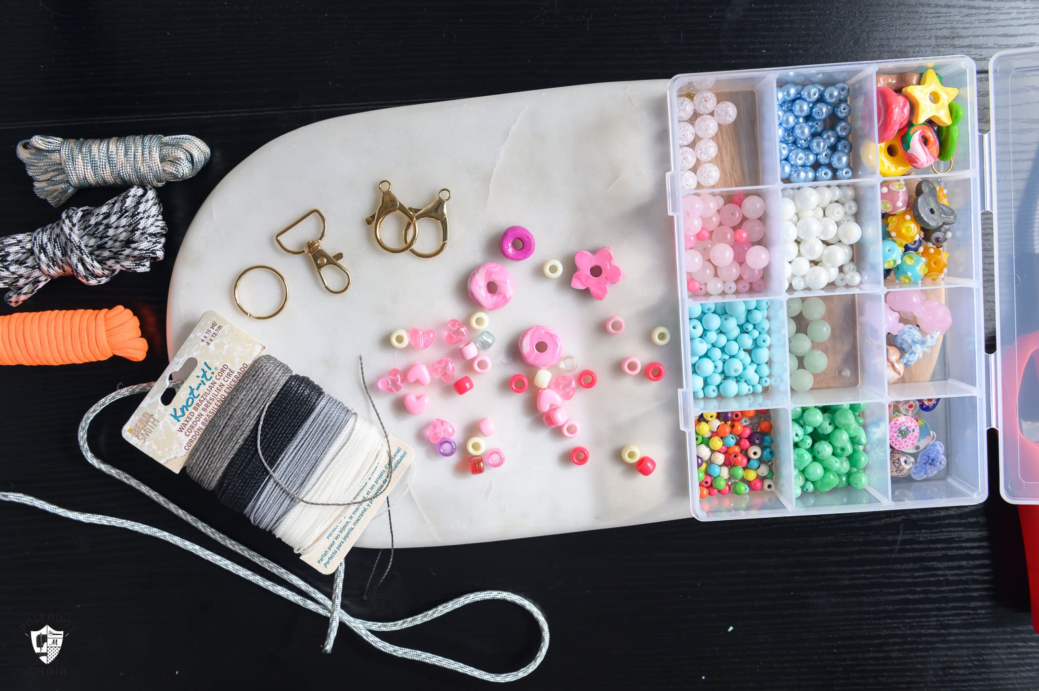beads, key chains and cords spread out on marble board.