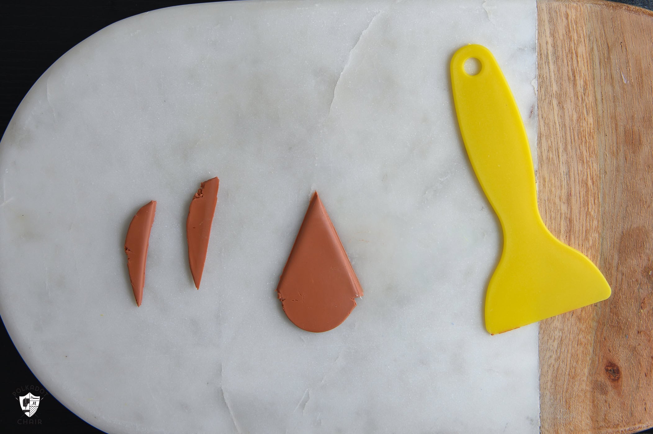 brown clay triangle with yellow clay tool.