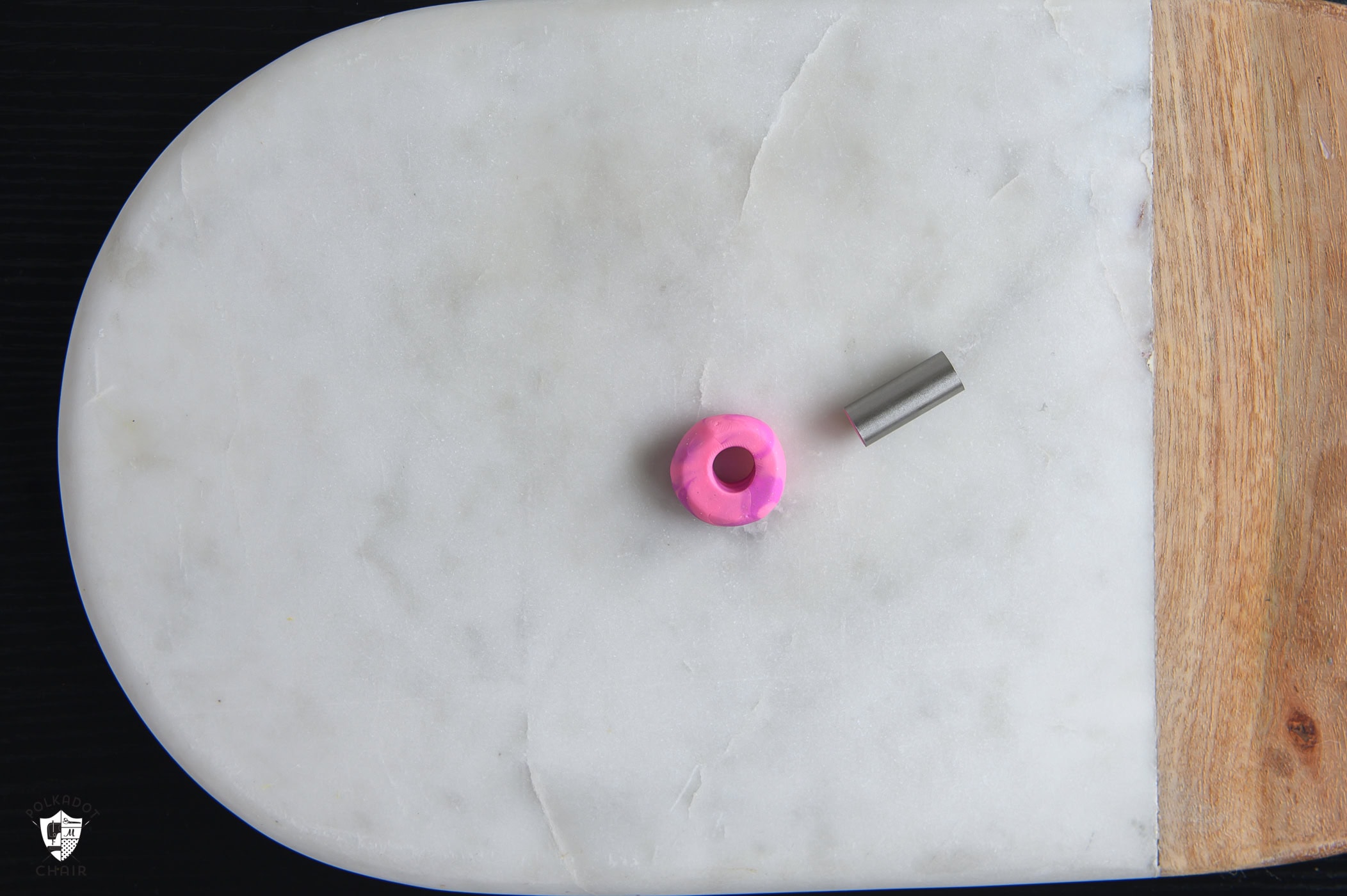 small clay pink swirl ball with hole cut out of the center making it a bead.