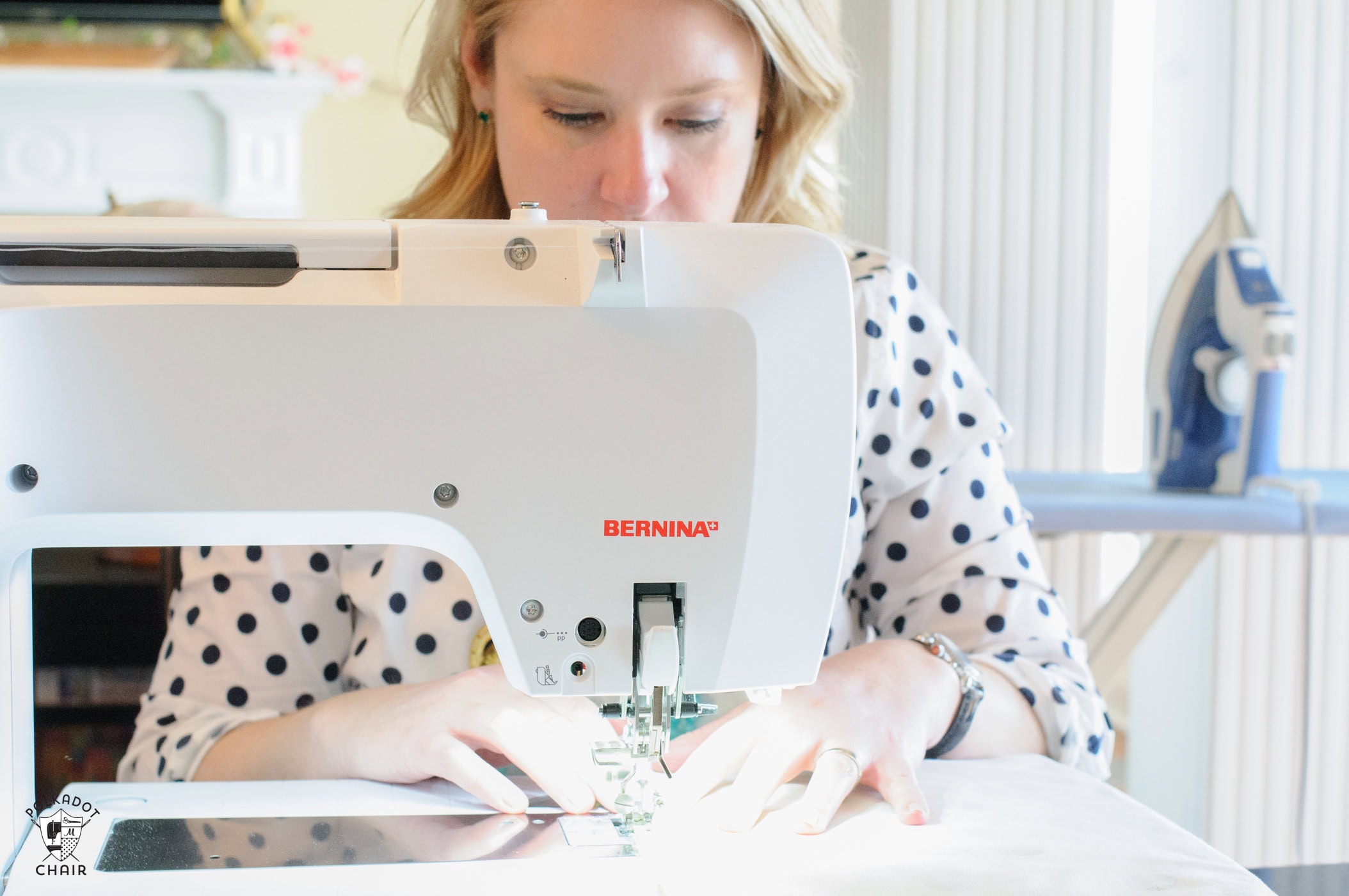 woman sitting at sewing machine sewing
