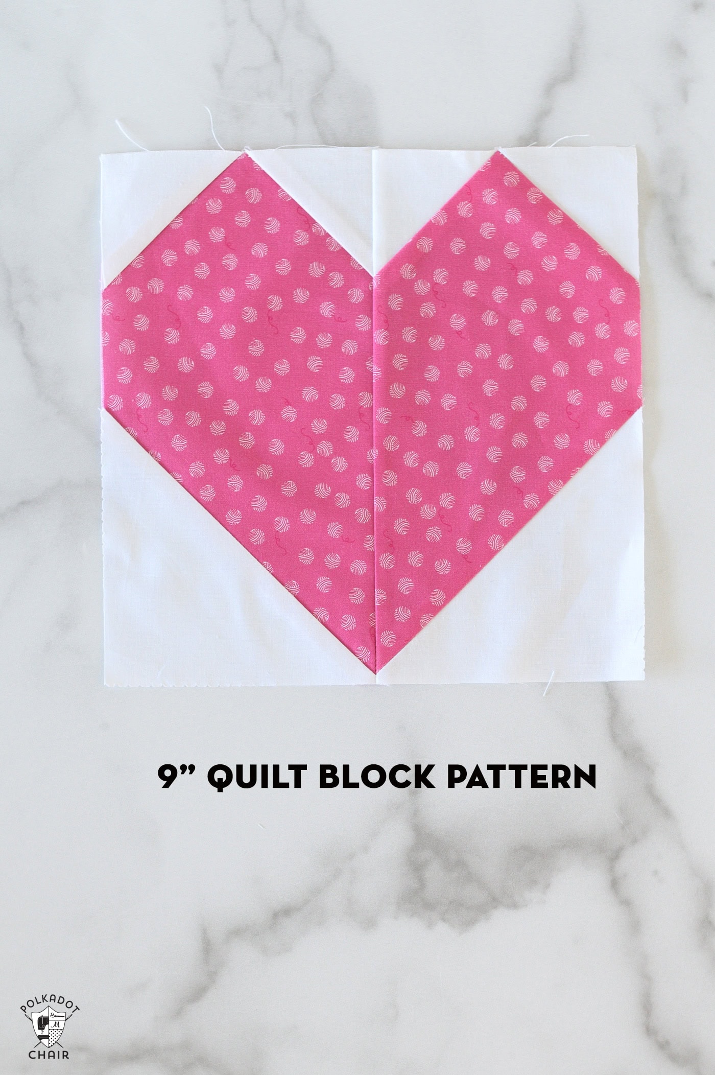 Pink and white heart quilt block on white table