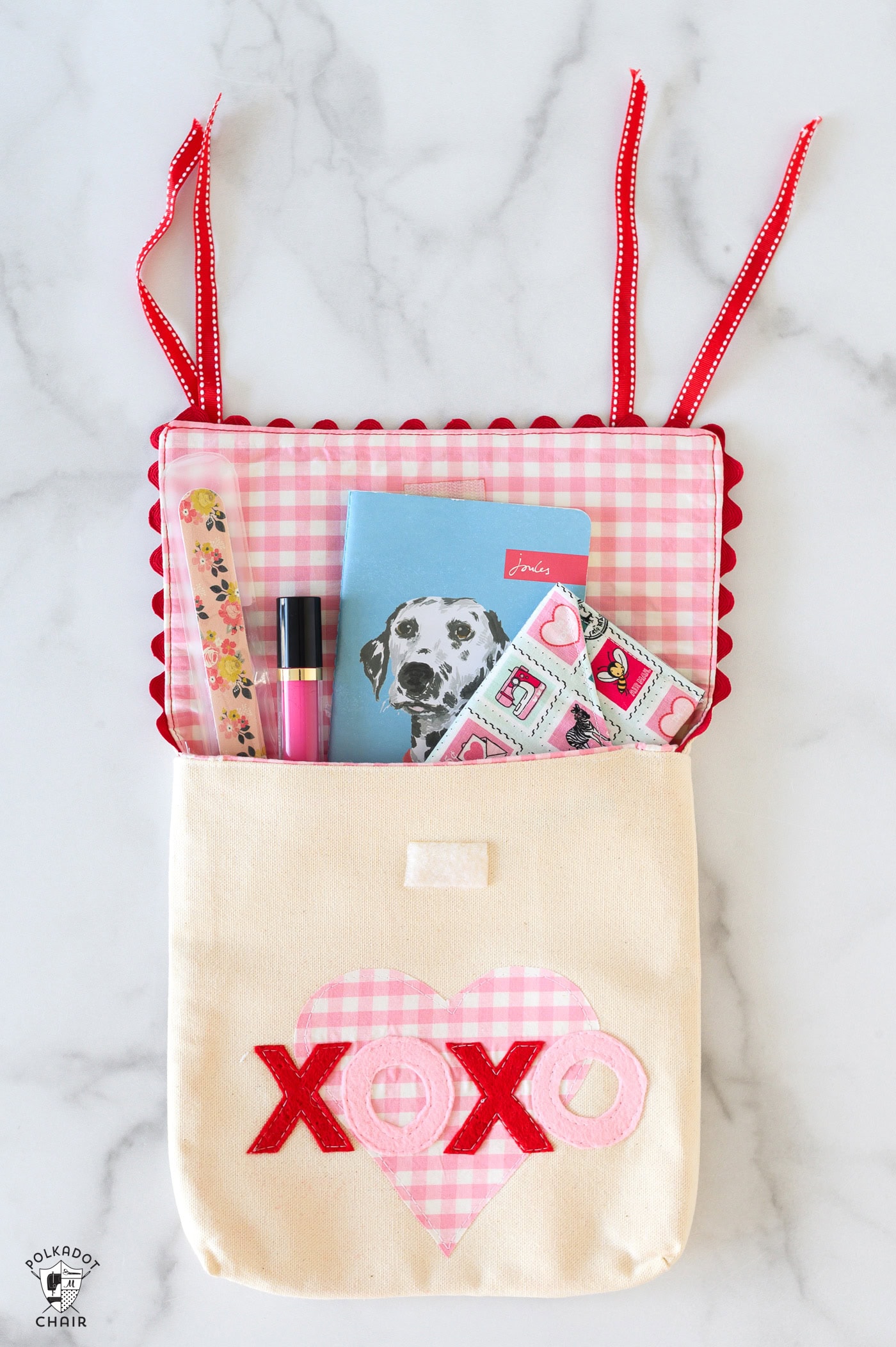 canvas chairbacker on white table. chairbacker has name made from felt and applique heart