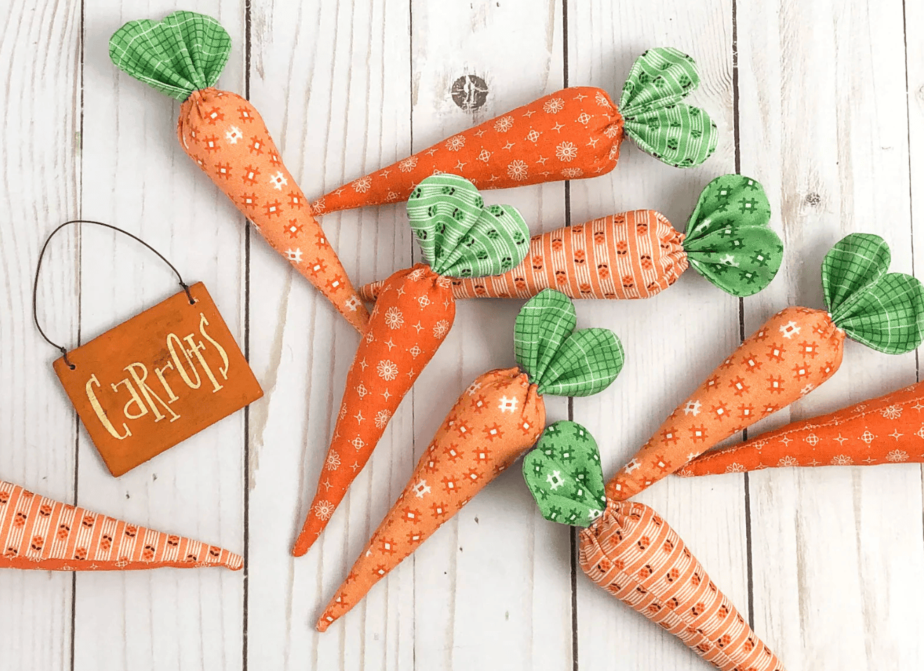 orange and green fabric carrots on white wood table