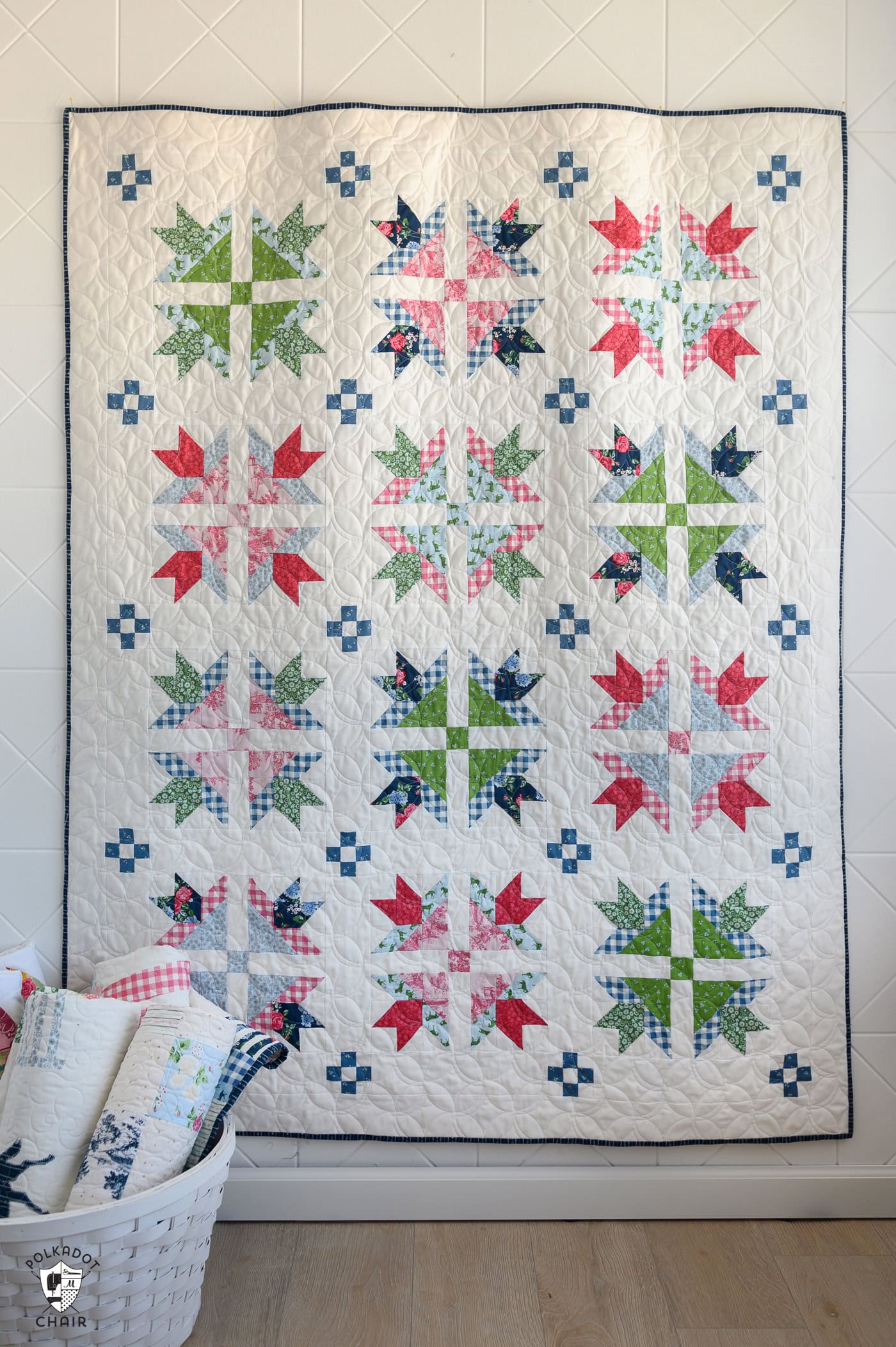 traditional red, green, pink and blue quilt hanging on wall