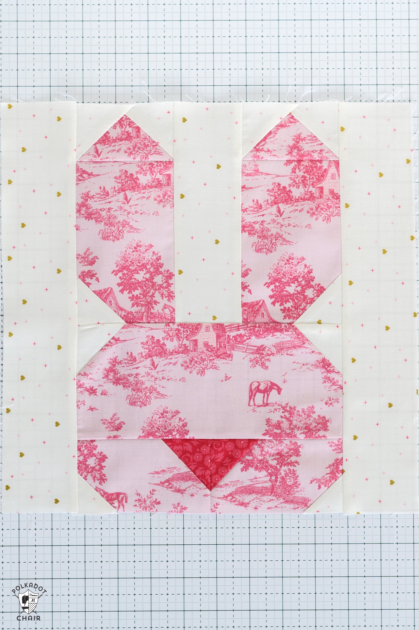 pink bunny quilt block on white cutting mat