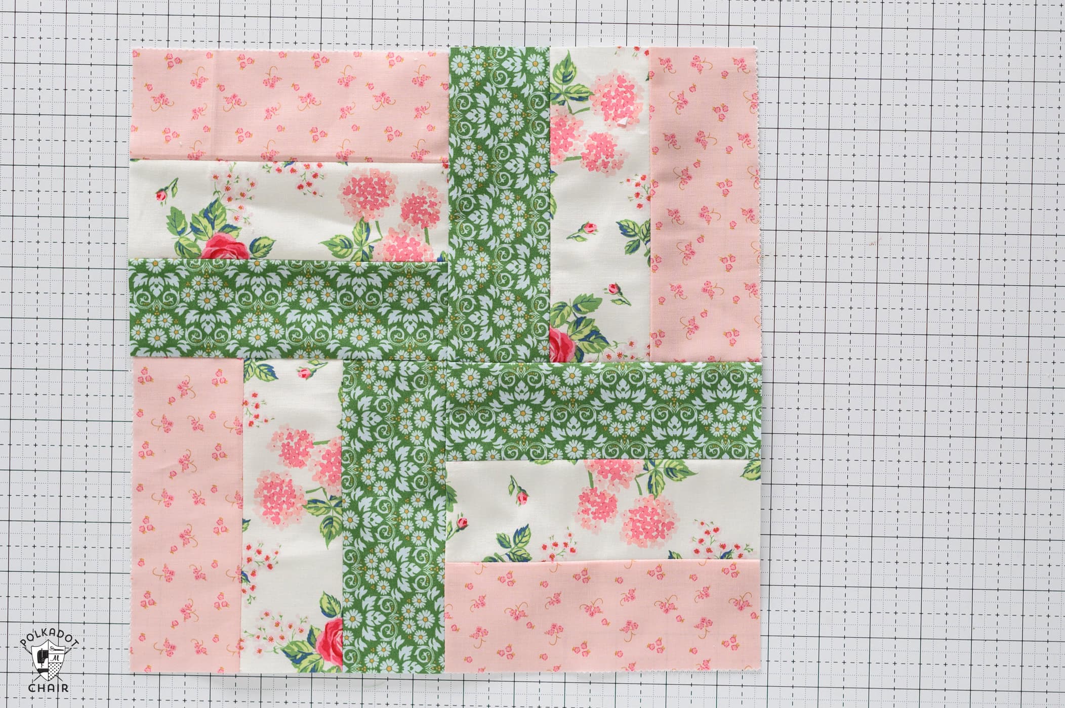 pink and green quilt block on white cutting mat