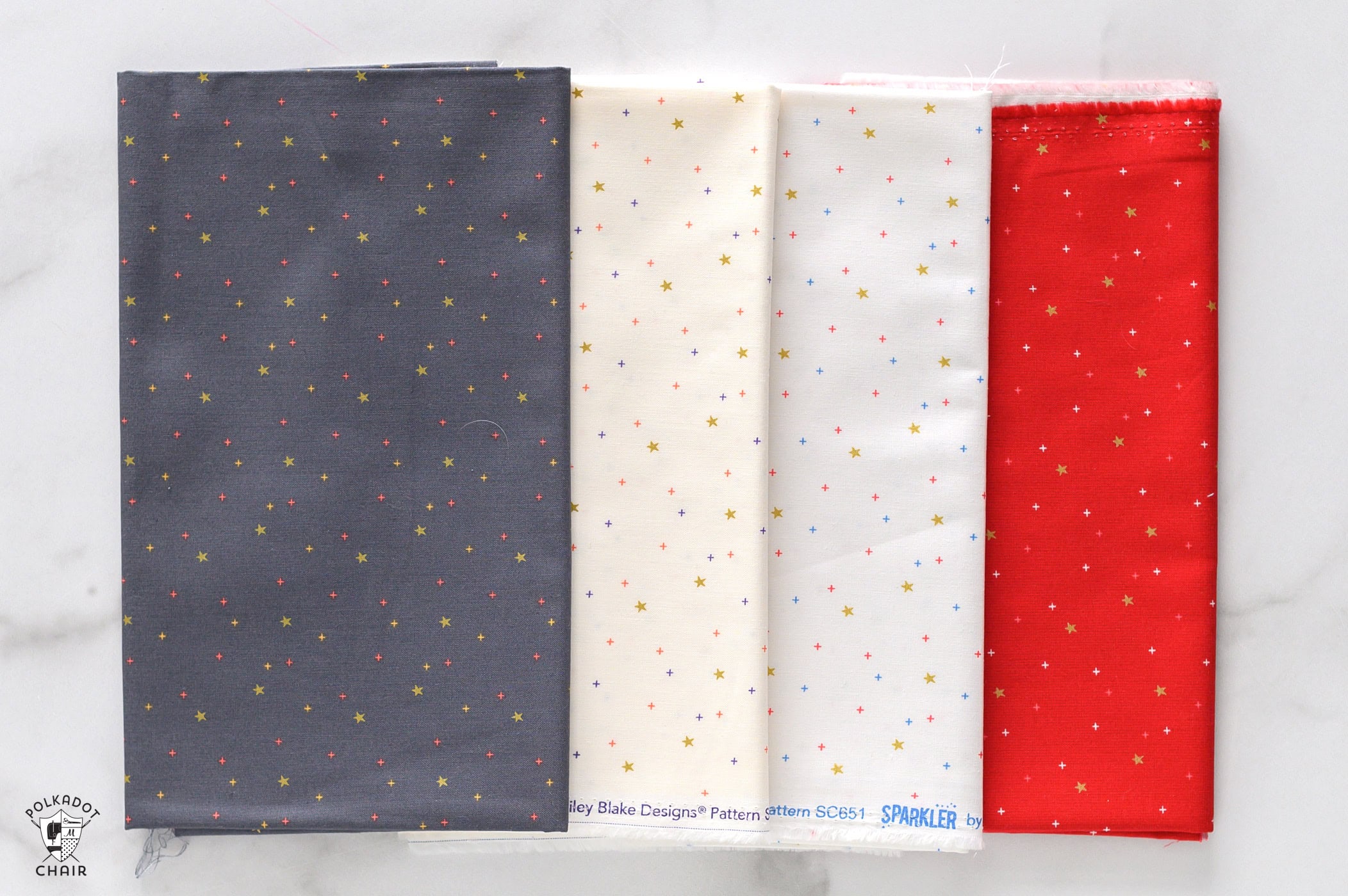 sparkler fabrics in bright colors folded on white marble table