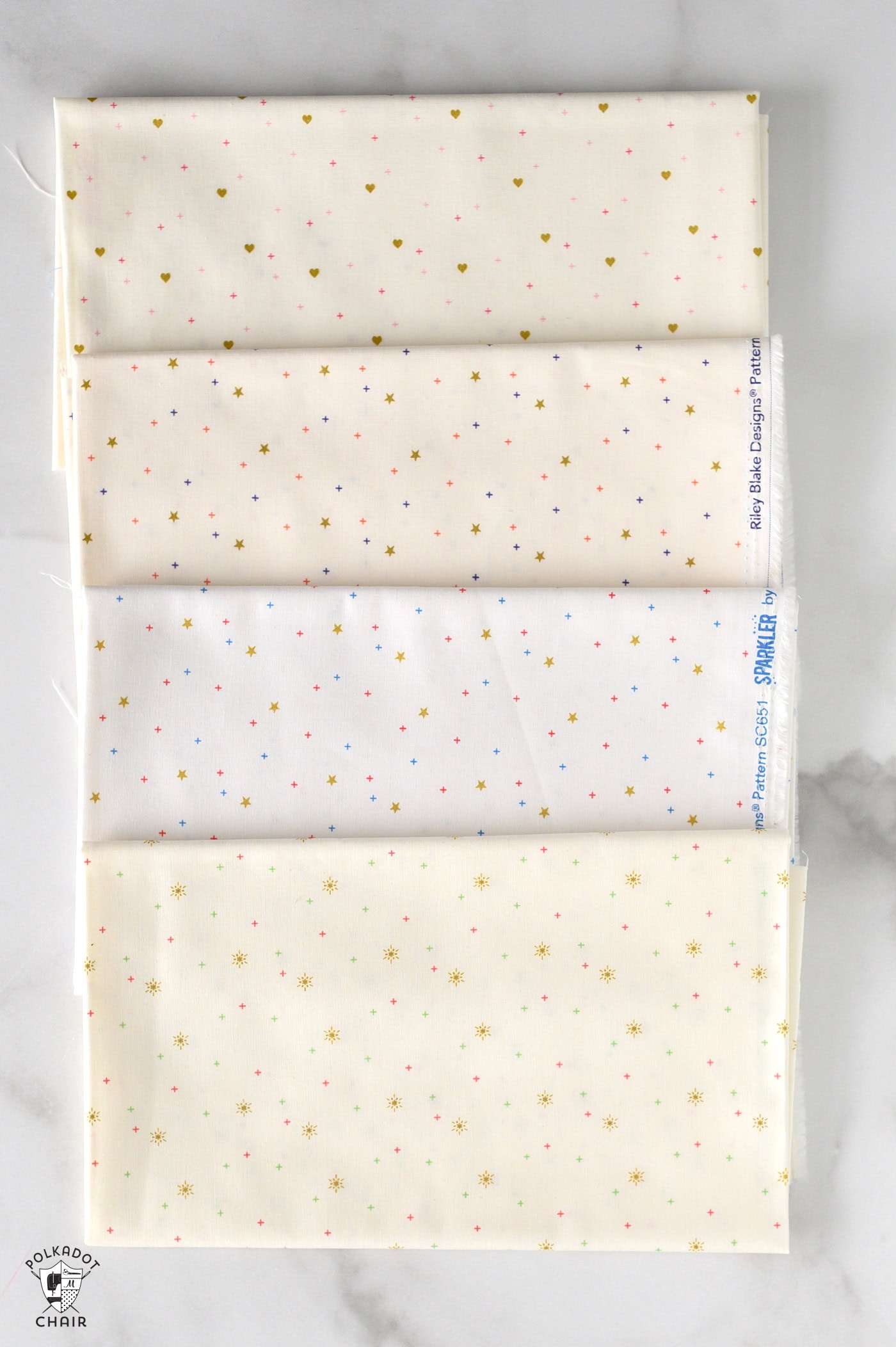 sparkler fabrics in neutral colors folded on white marble table