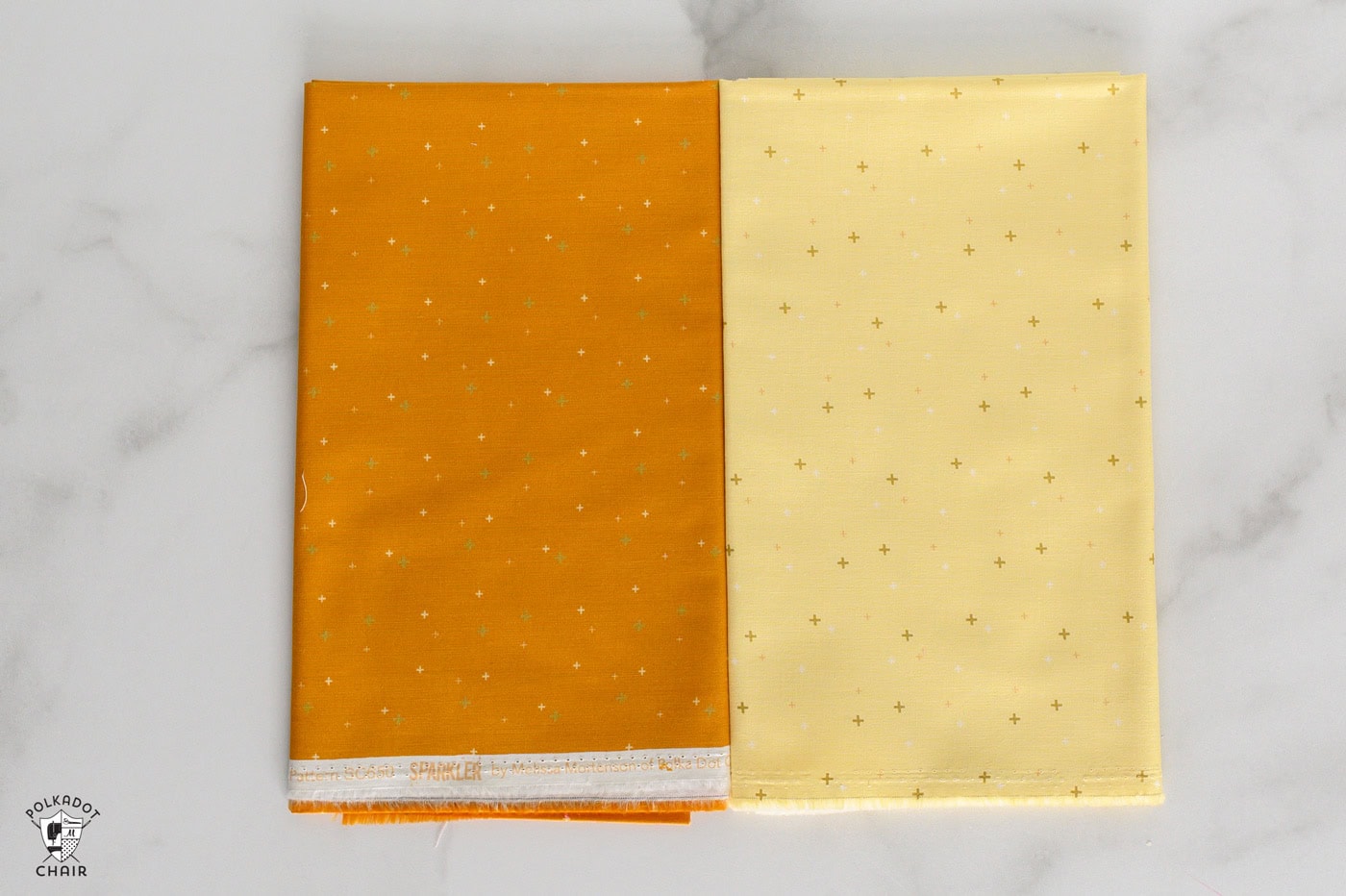 sparkler fabrics in bright colors folded on white marble table