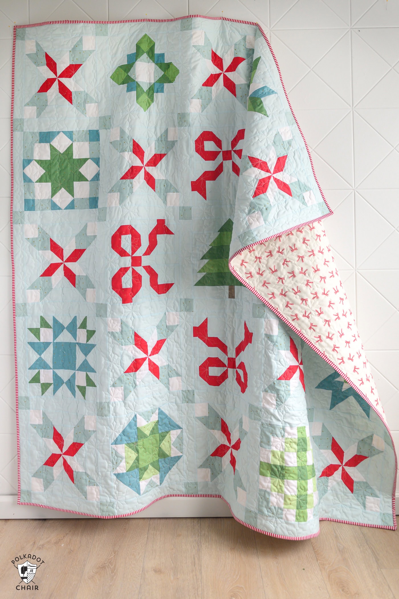 Colorful Christmas quilt with red, green, and blue patterns on a white background.