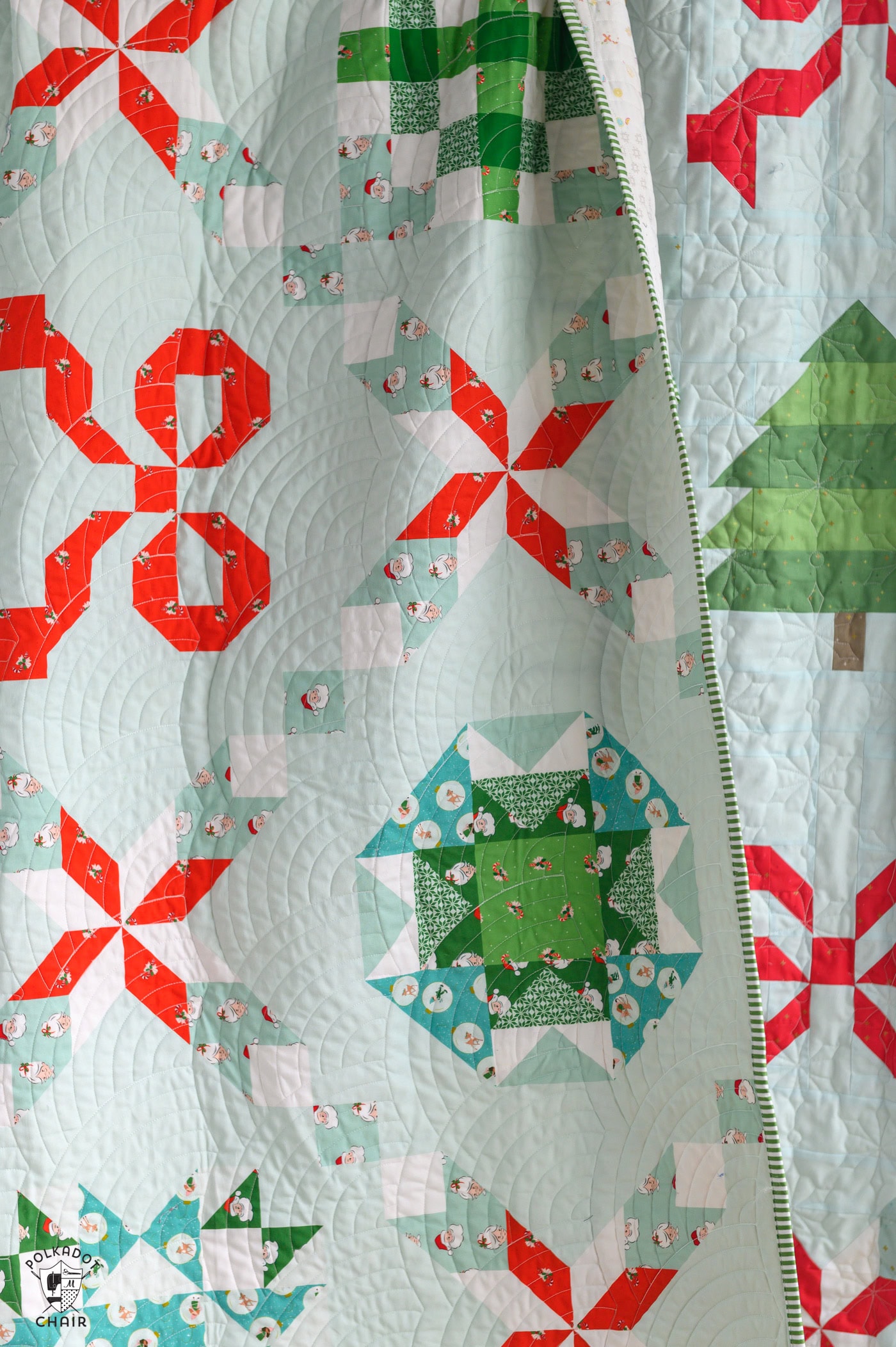 Colorful Christmas quilt with red, green, and white patterns.