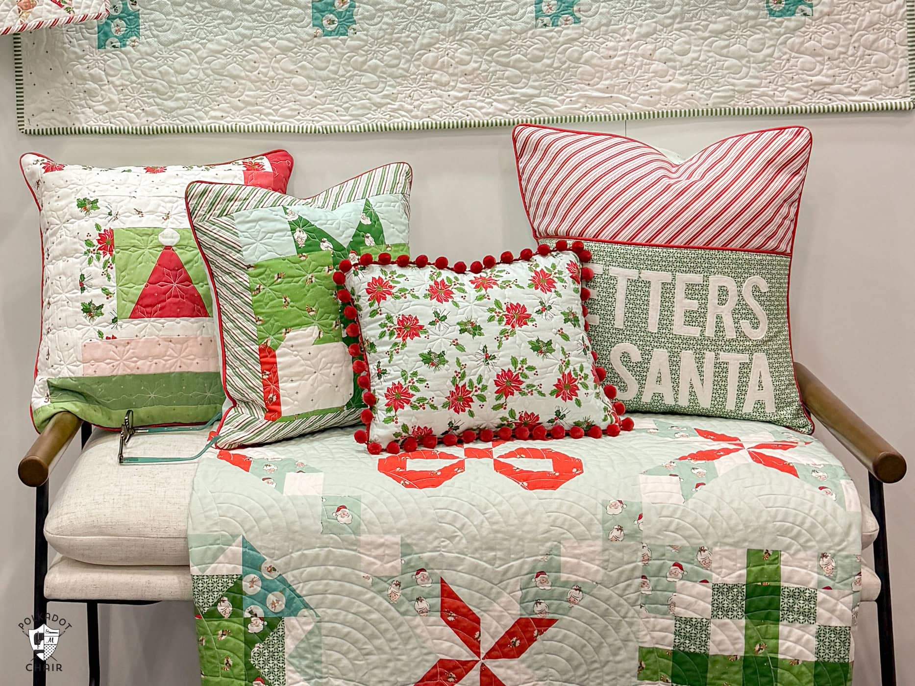 photo of booth at quilt market featuring a variety of christmas quilts and pillows