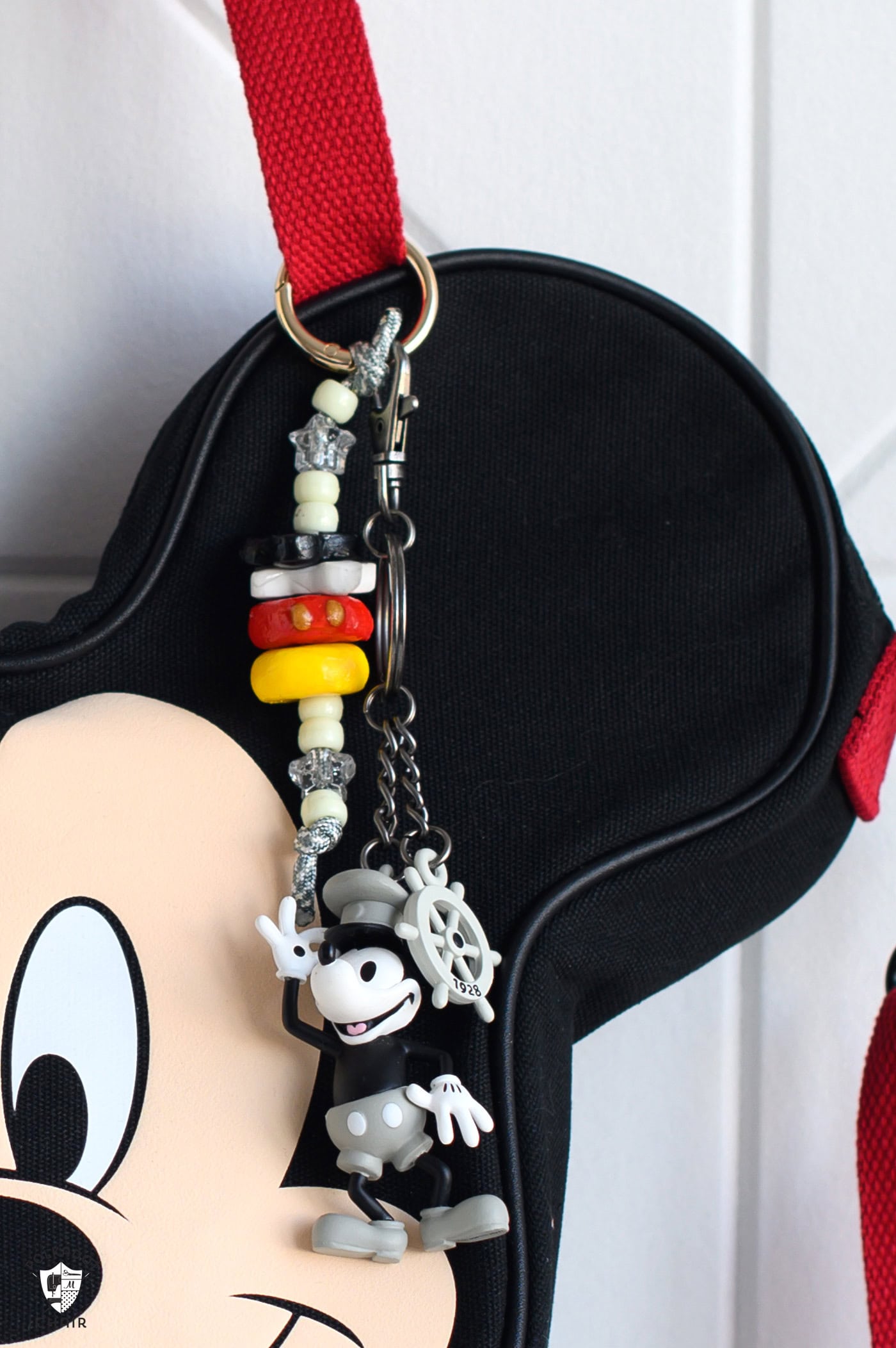 close up of bag charms and mickey keychain on bag