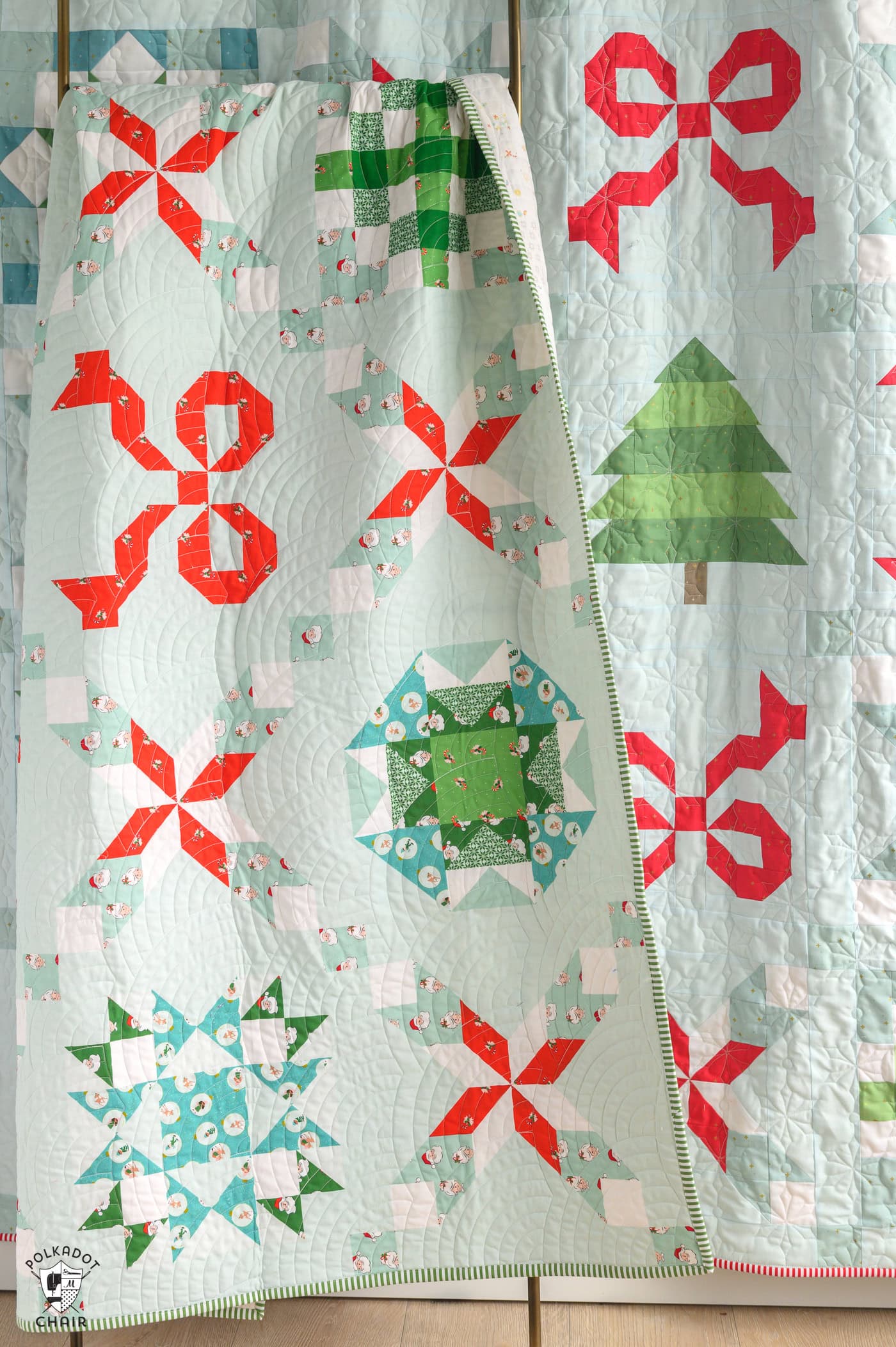 christmas quilt with bows and stars hanging on wall