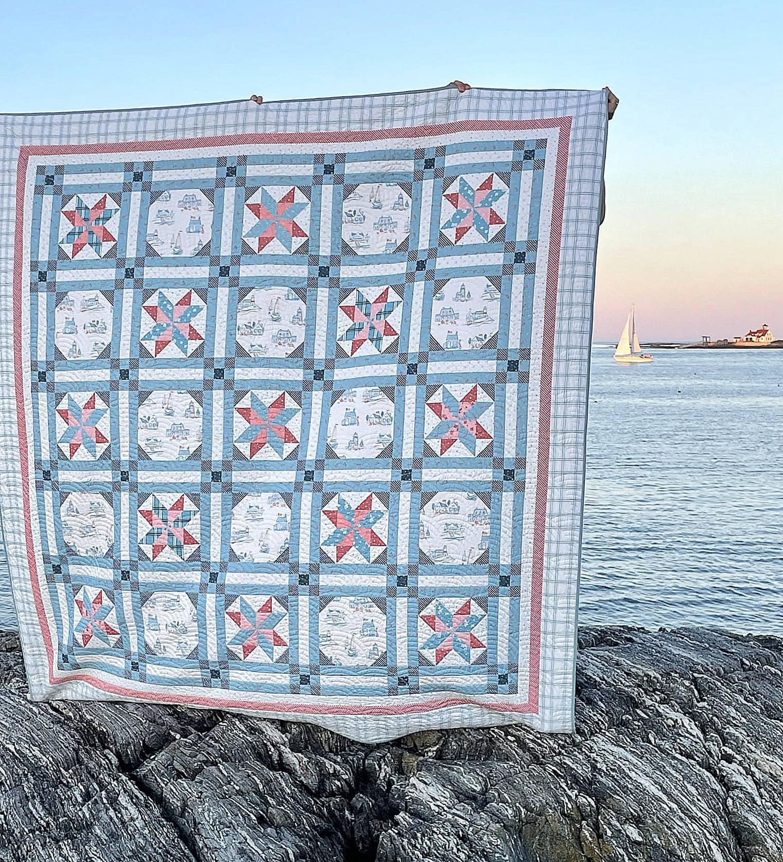 blue star quilt with red border on beach