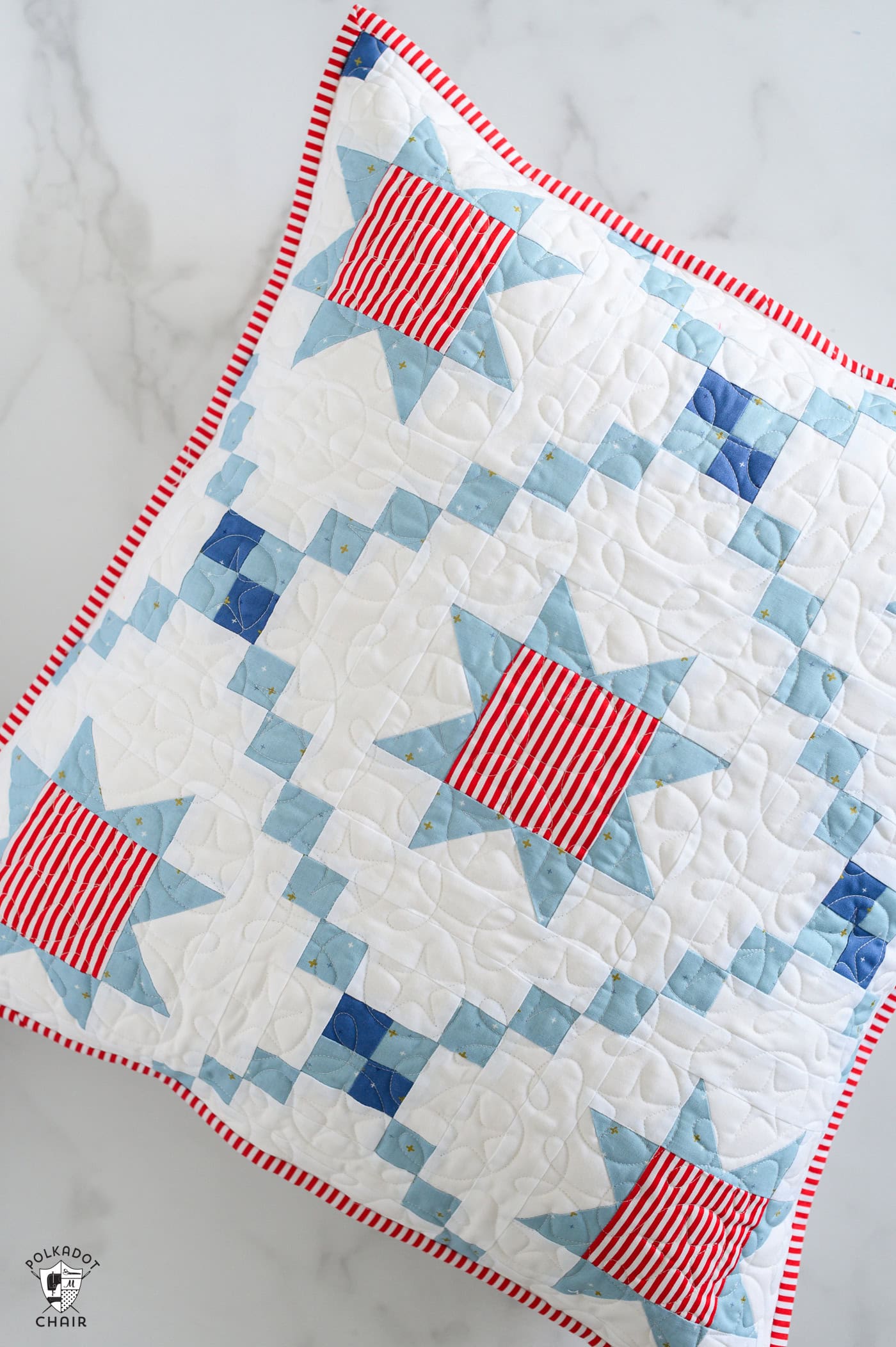 quilted red, white and blue pillow pattern on white marble table