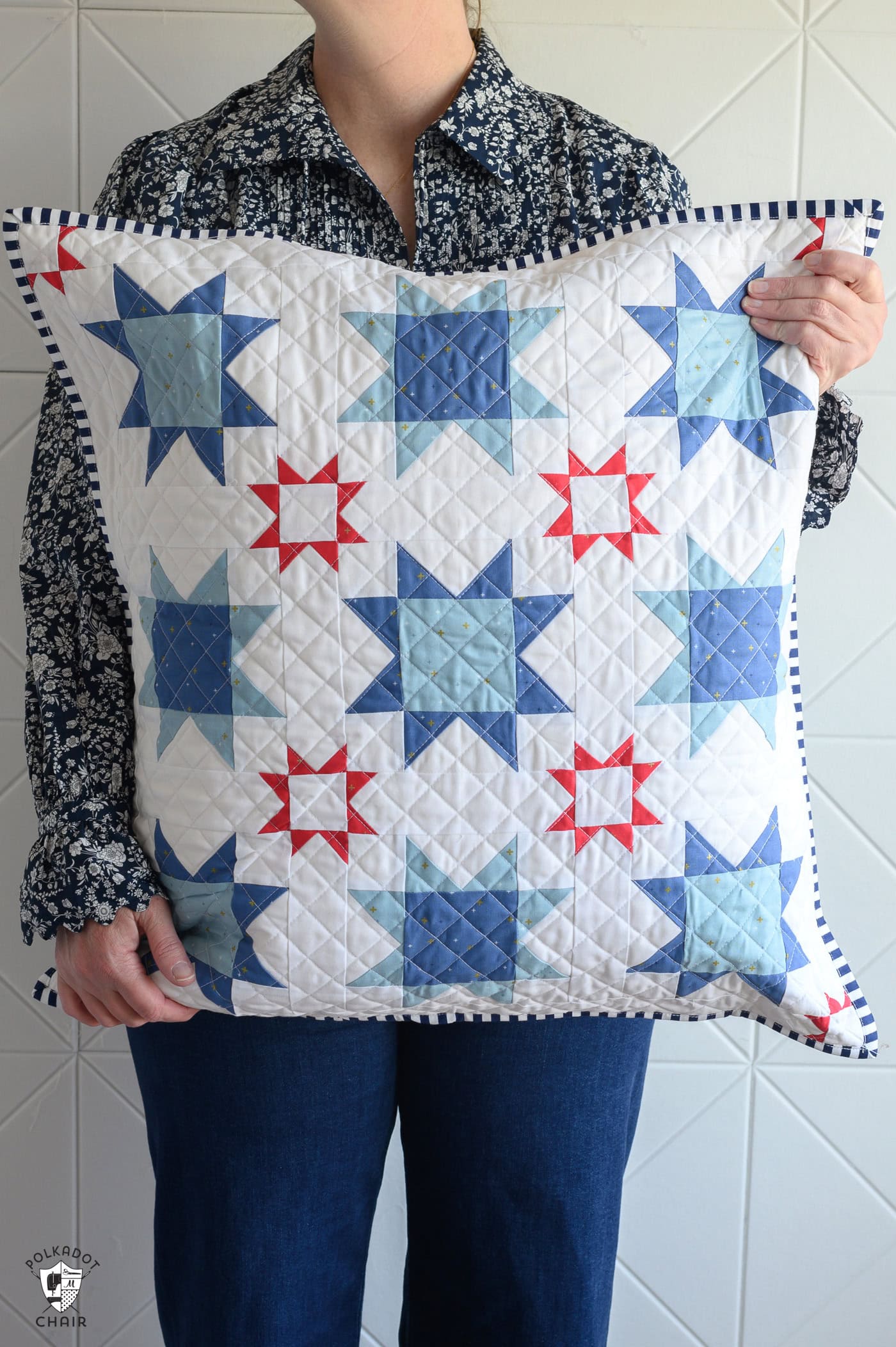 woman holding a white pillow with blue quilted stars