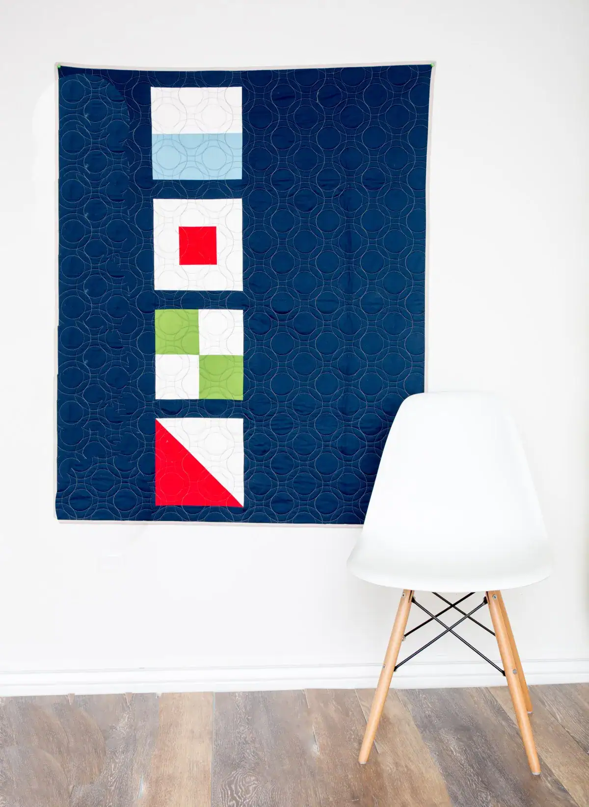 navy quilt hanging on wall with four nautical quilt blocks