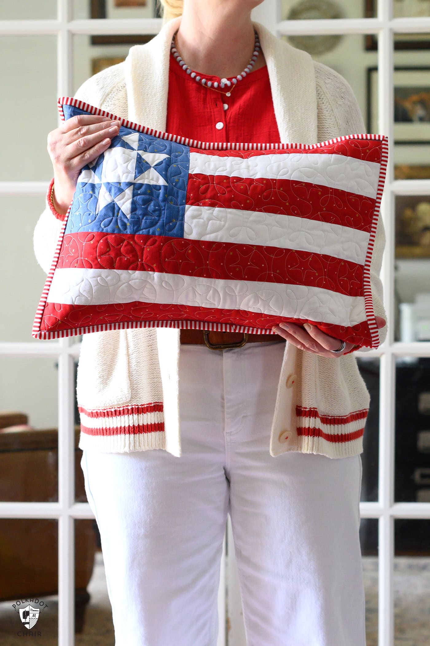 woman holding american flag pillow in front of doors