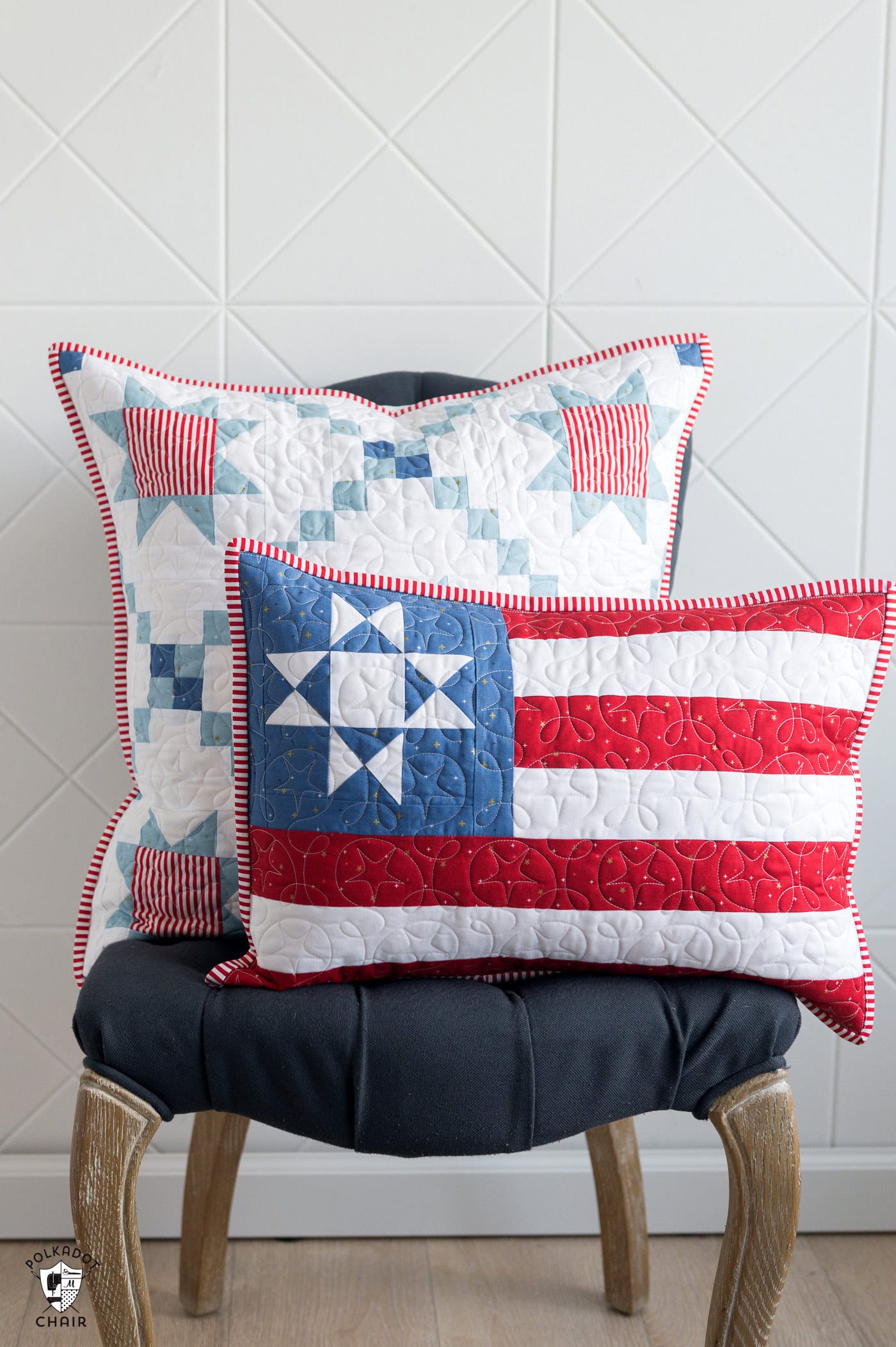 Two red white and blue pillows on chair in front of white wall