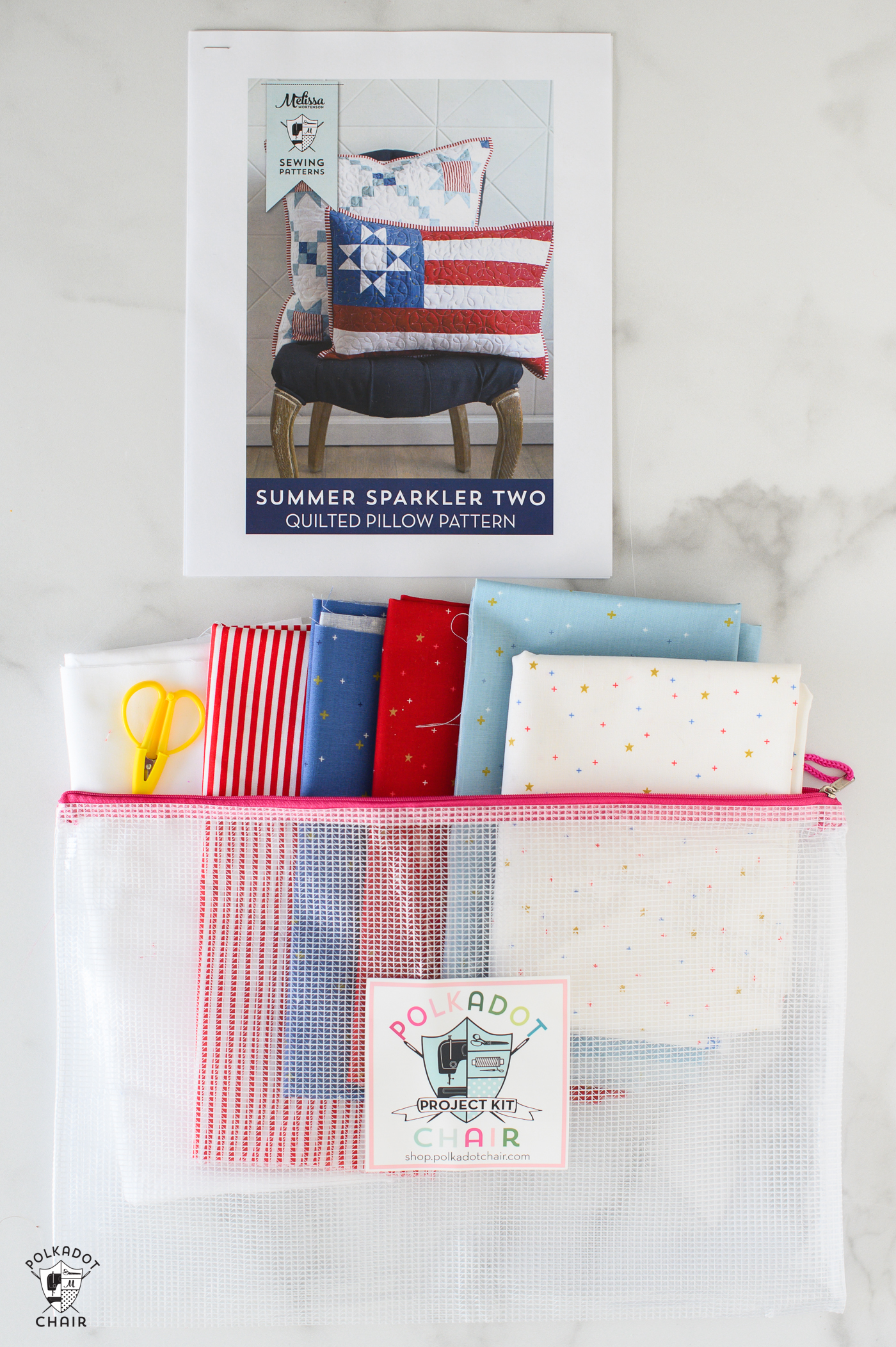contents of quilt kit, fabric, pattern and zip bag on white table