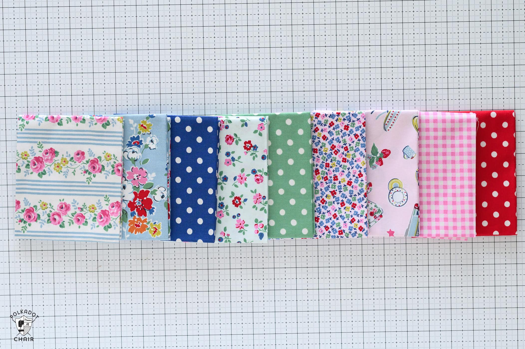 pink, blue and aqua colorful print fabric fat quarters on white cutting mat