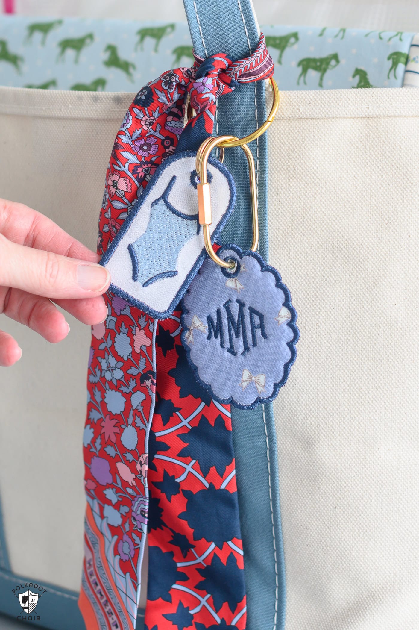 two embroidered tags and a silk scarf on tote bag.