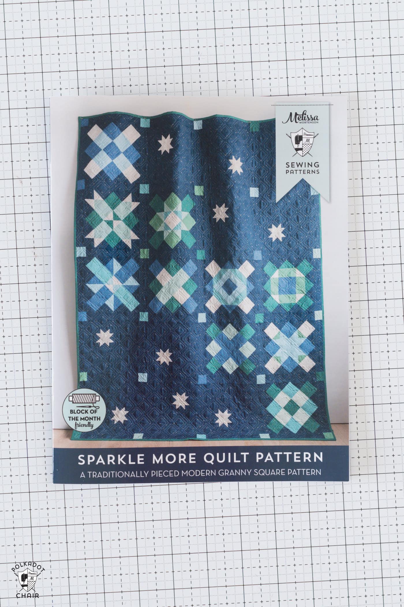 quilt pattern with navy quilt on cover on white cutting mat