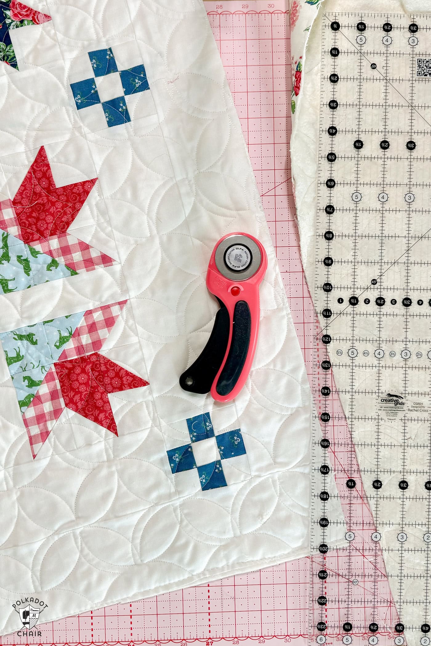 rotary cutter and quilt on pink cutting mat with ruler
