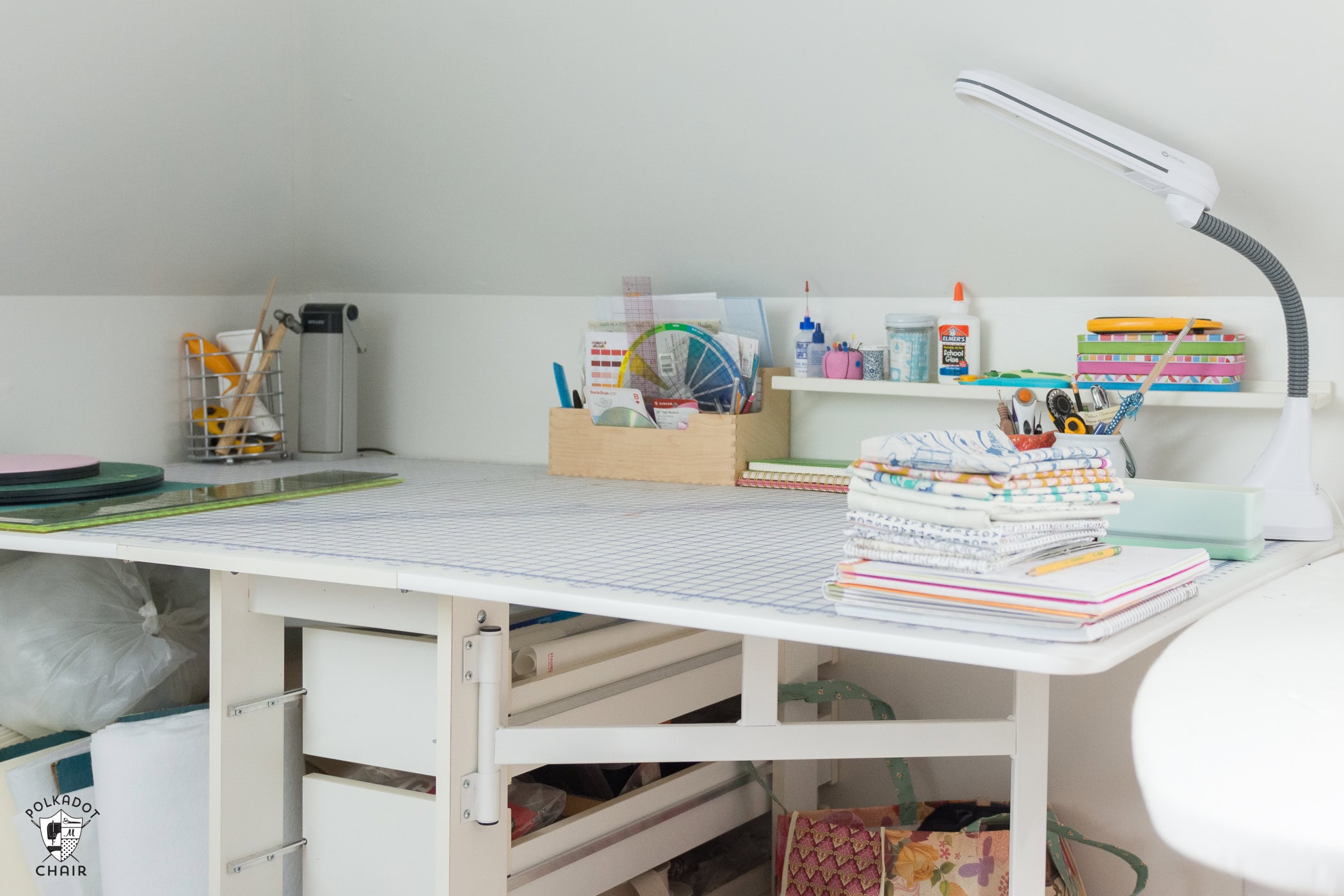 cutting table with cutting mat in sewing room with white wall and sewing notions