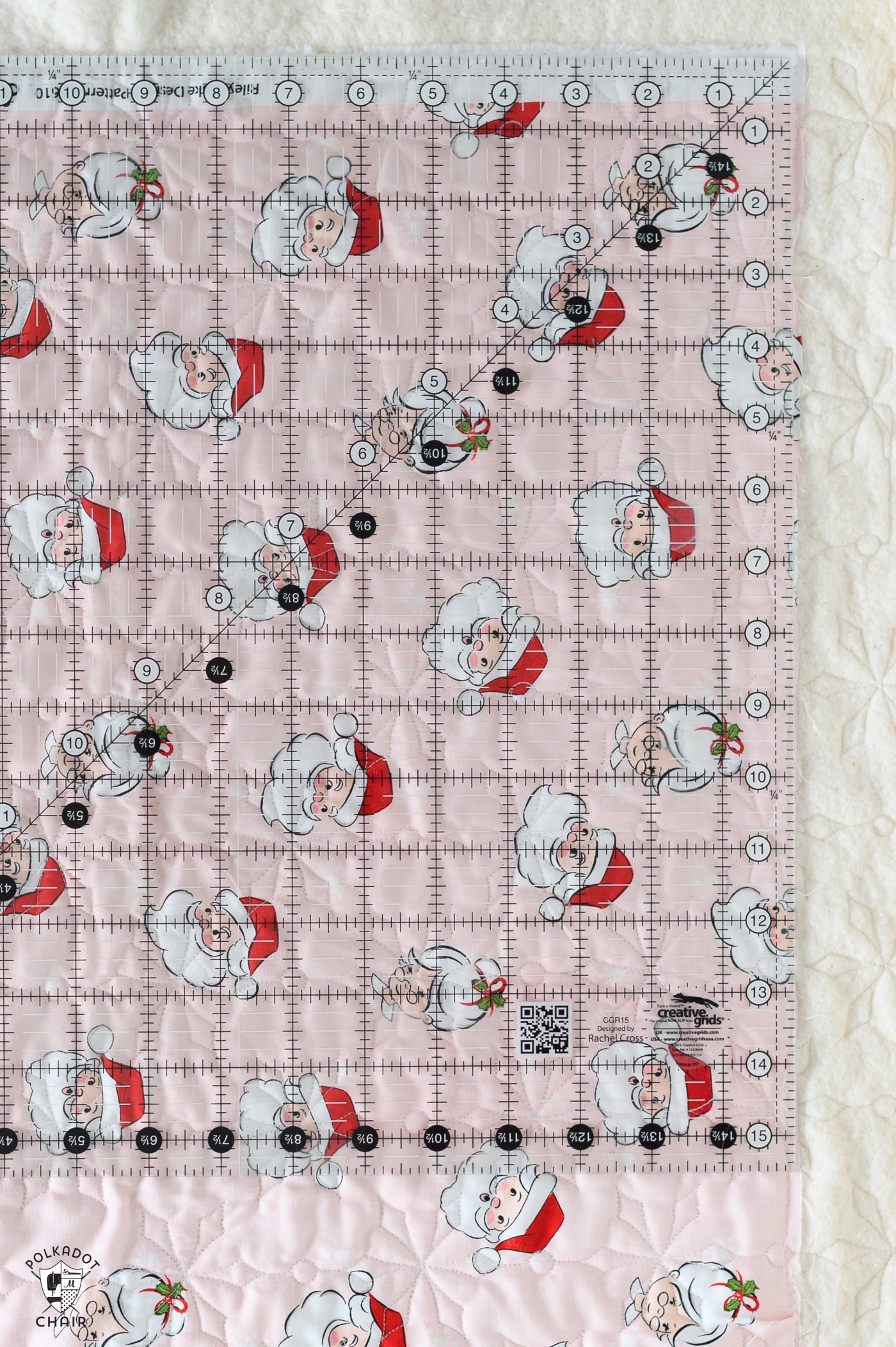 large quilting ruler on top of quilted pink fabric