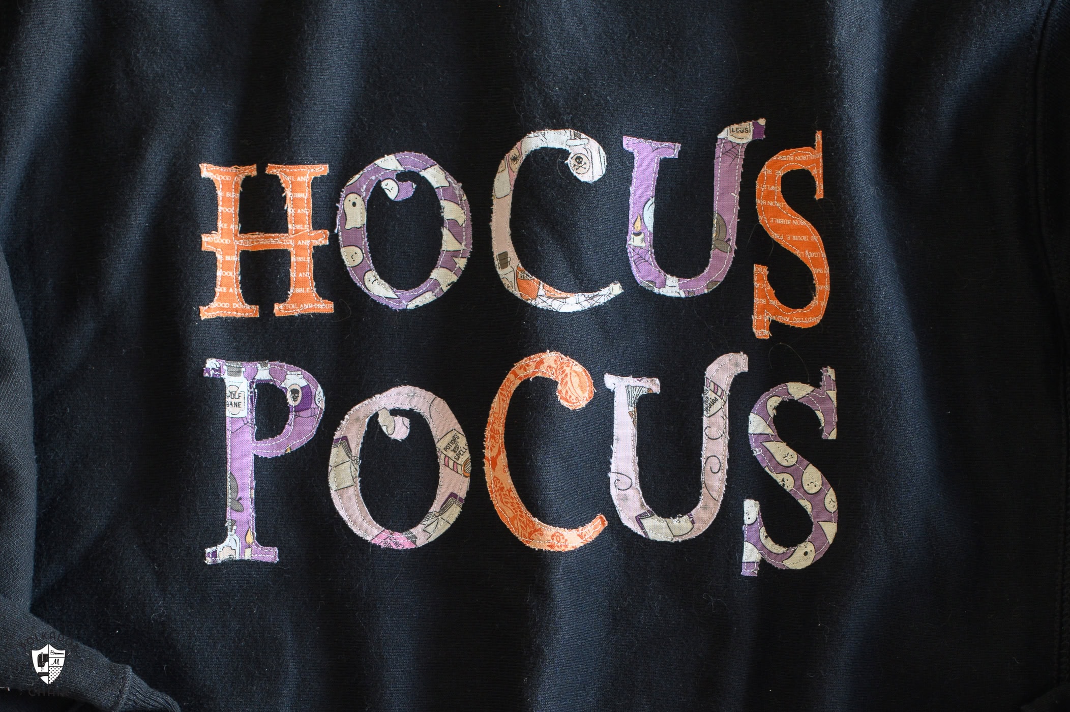 close up of Hocus Pocus Halloween letters on black sweatshirt