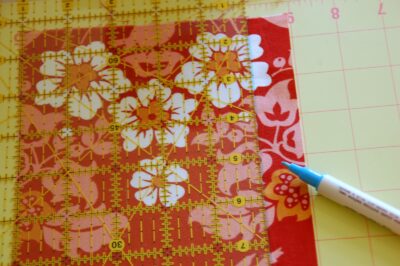 red, blue and coral fabric during construction process with sewing notions
