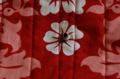 red, blue and coral fabric during construction process with sewing notions